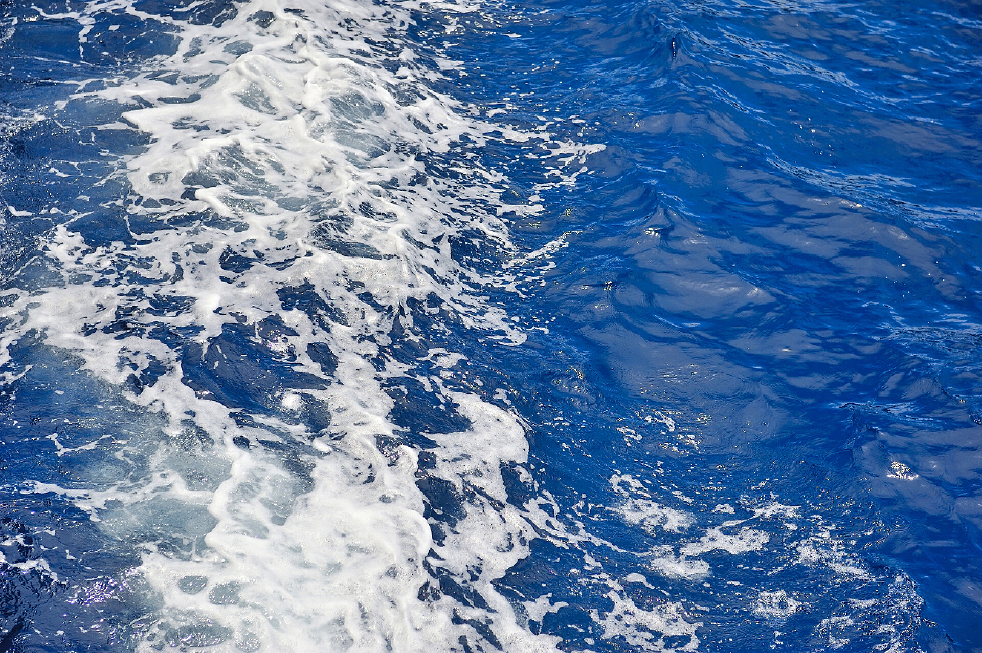 蓝色海面上海水波涛汹涌蓝色的大海水表面运动与泡沫