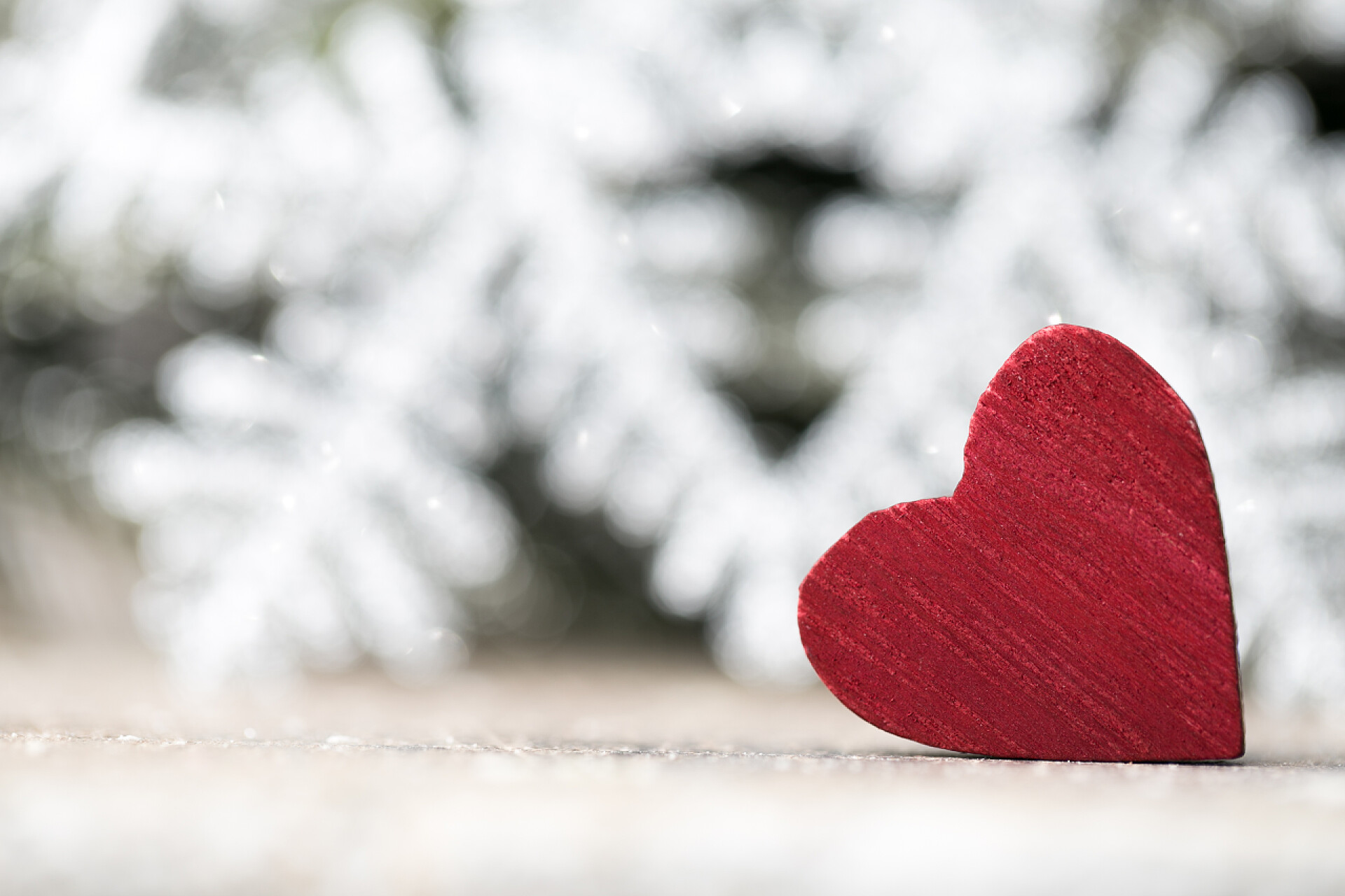 雪花背景前的爱心装饰品特写复古风格的圣诞背景。贺卡.