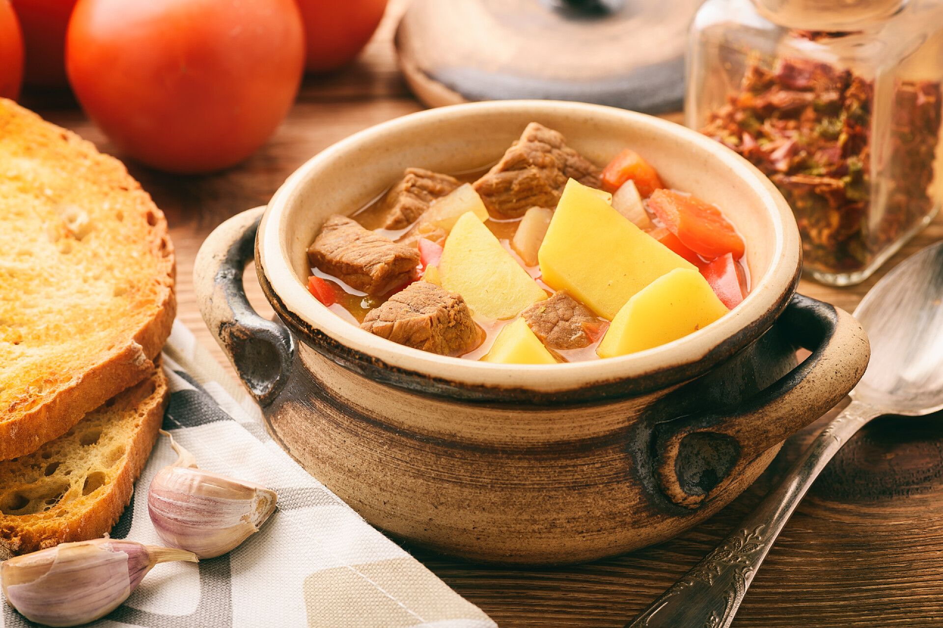 一碗土豆胡萝卜牛肉汤热热的汤炖棕色木制的桌子上.