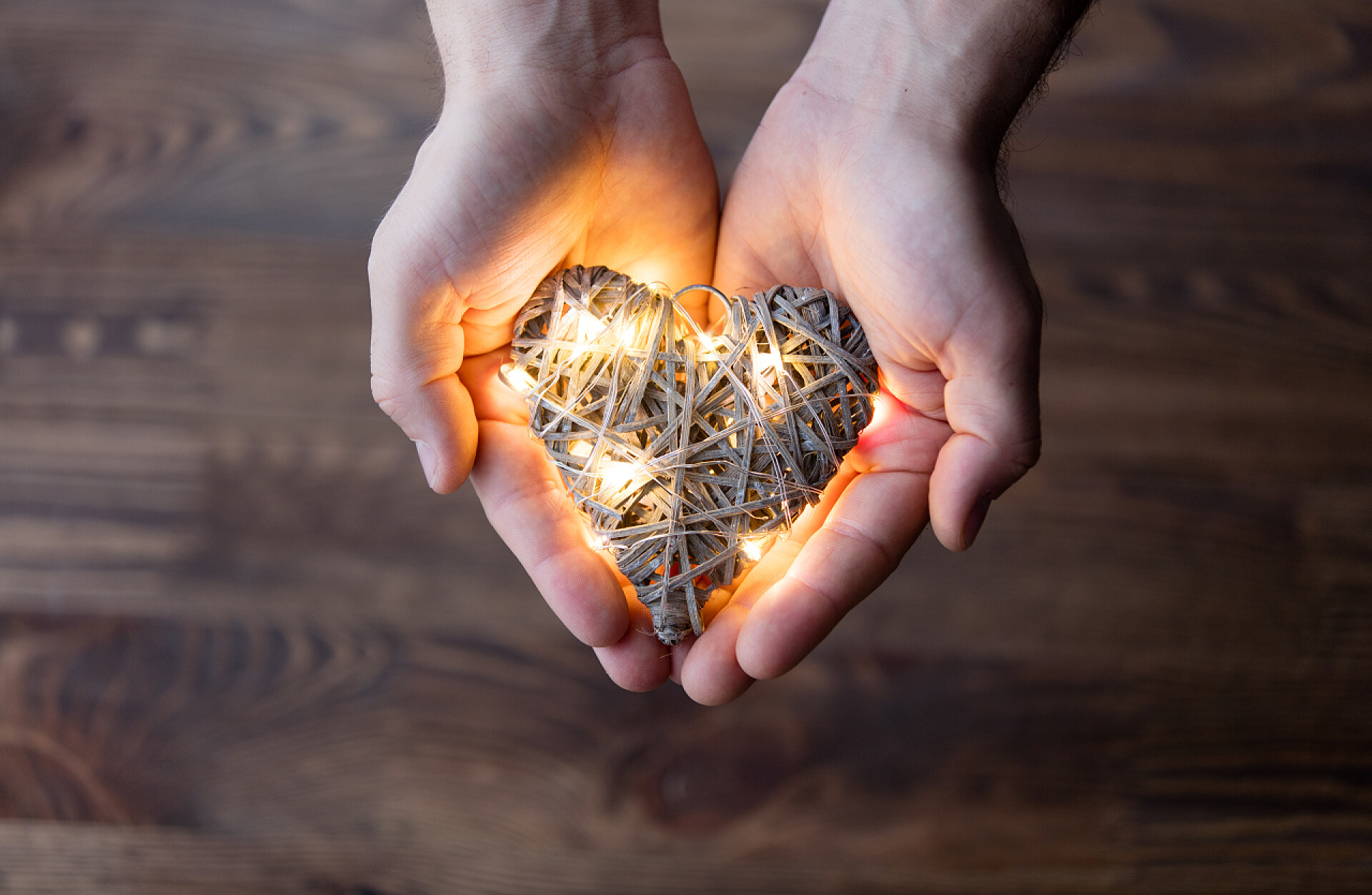 男子手持心形灯饰的特写男人抱着一个心的形状玩具