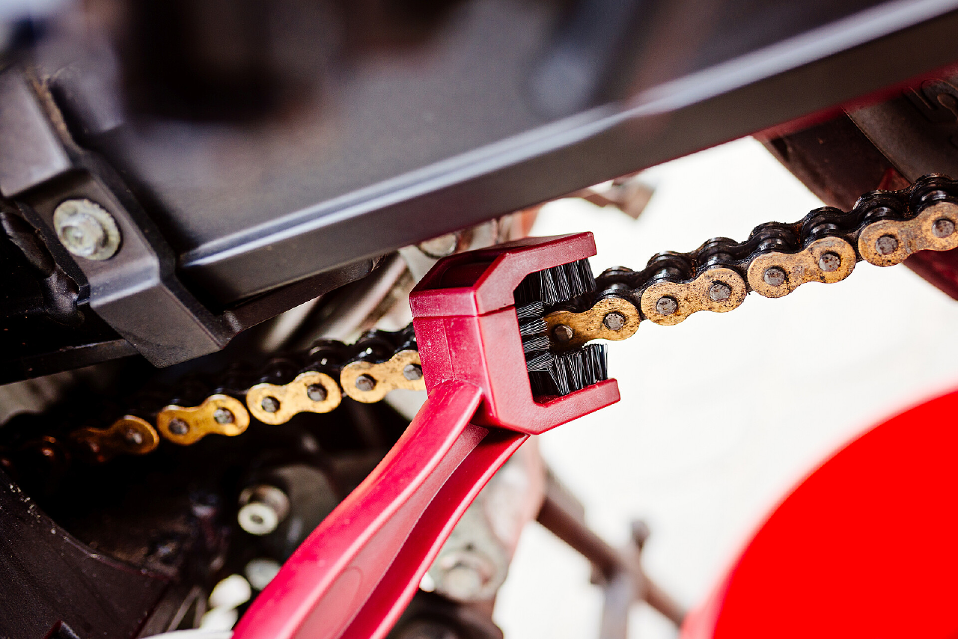 用红色的刷子清洗摩托车链条清洗的摩托车链条