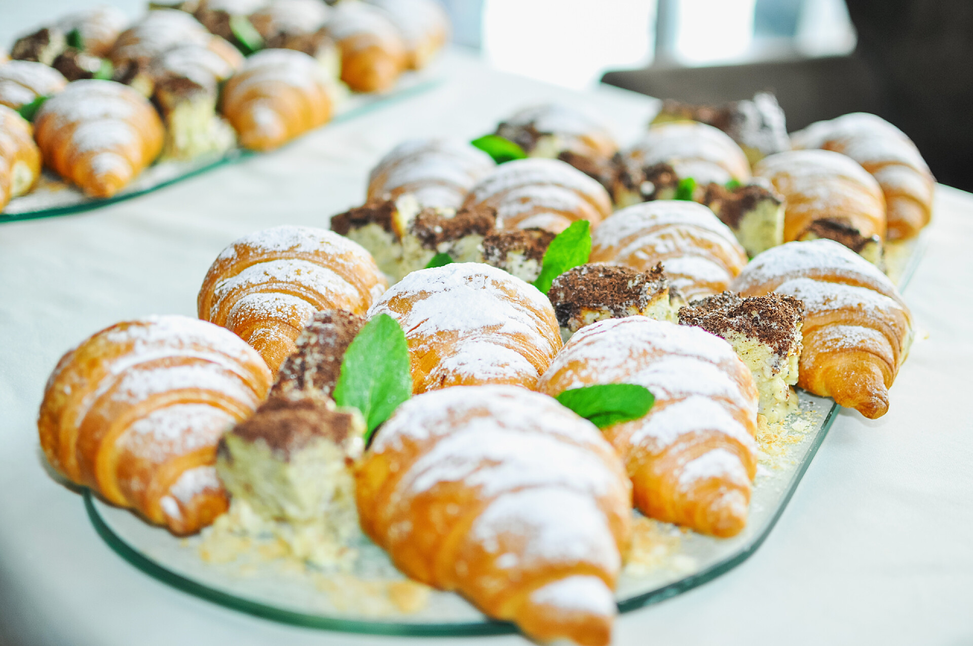 自助餐桌上牛角面包特写各式各样的新鲜糕点在自助餐桌上。羊角面包和蛋糕