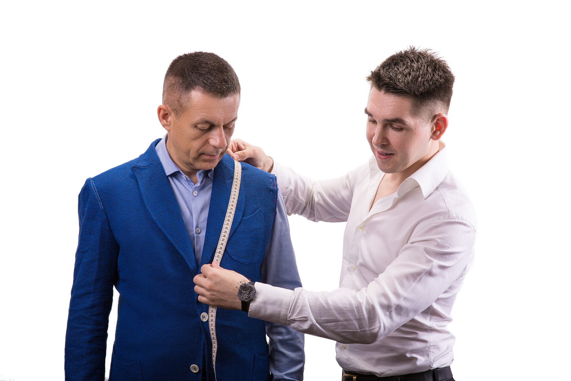 裁缝师在为男子量衣服英俊的男人，在模型拟合的西装在工作室的肖像