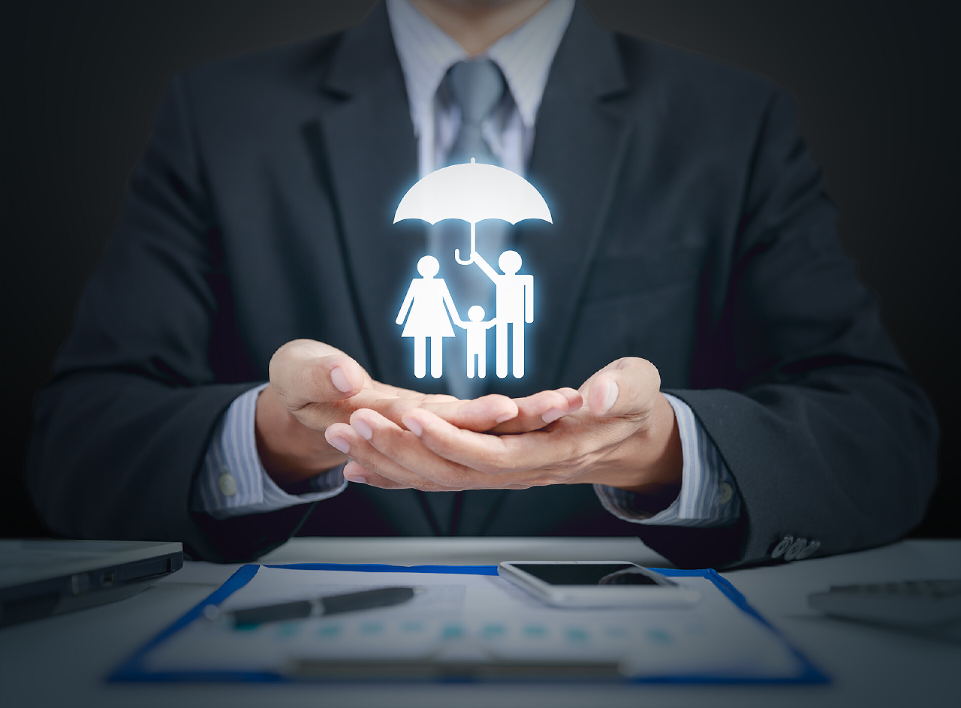 家庭和健康保险概念图商人目前家庭和健康保险概念用的伞