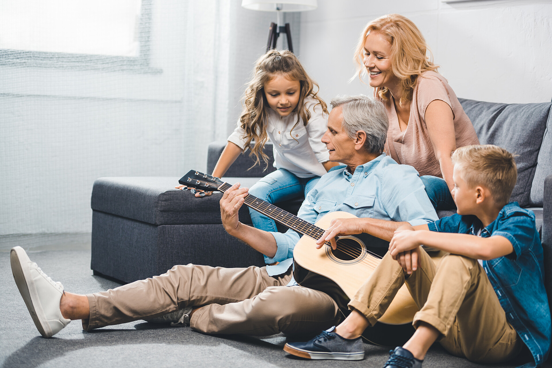 围在一起弹吉他唱歌的一家人家庭在吉他上玩