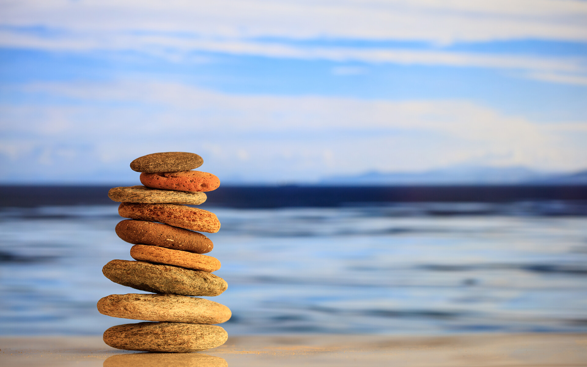 蓝天白云下在沙滩堆石块景观禅宗的石头堆栈上蓝蓝的天空和大海背景