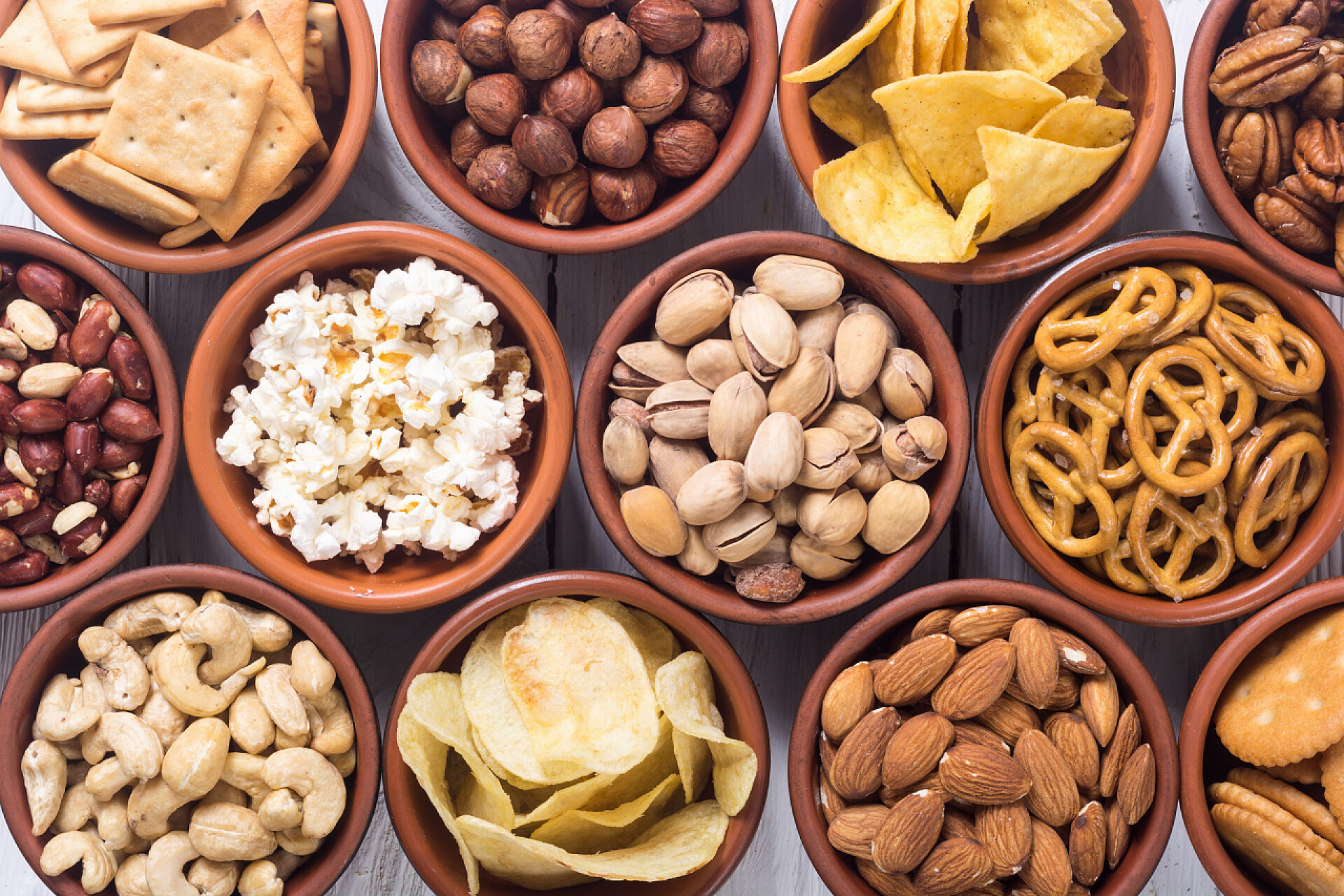 白色桌子上的各种各样的坚果和零食混合的小吃