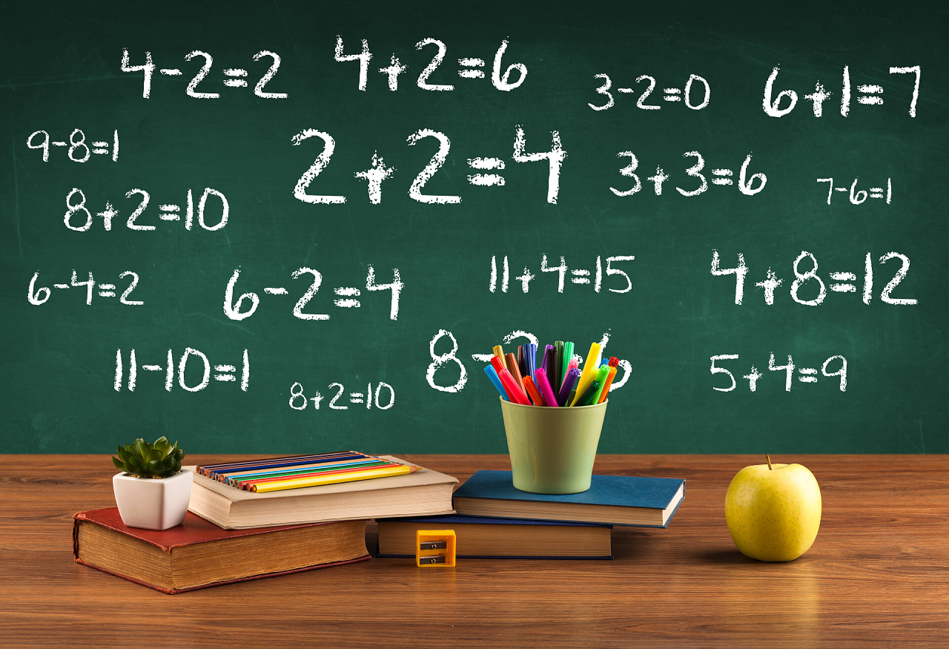 黑板上的数字和桌子上的用品学校黑板，书堆成堆