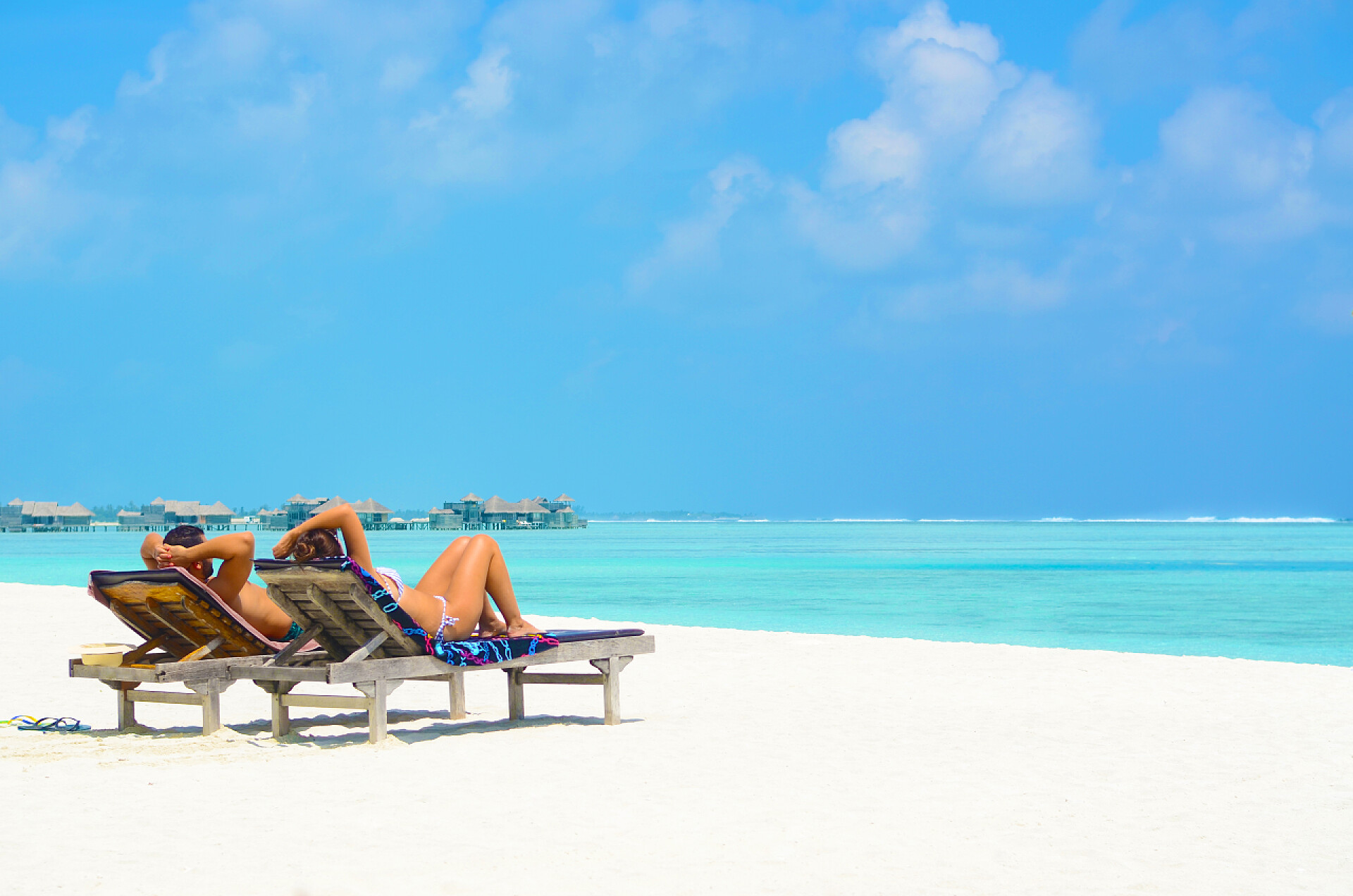 夏天的时候在海边躺椅上的情侣度假和旅游的概念