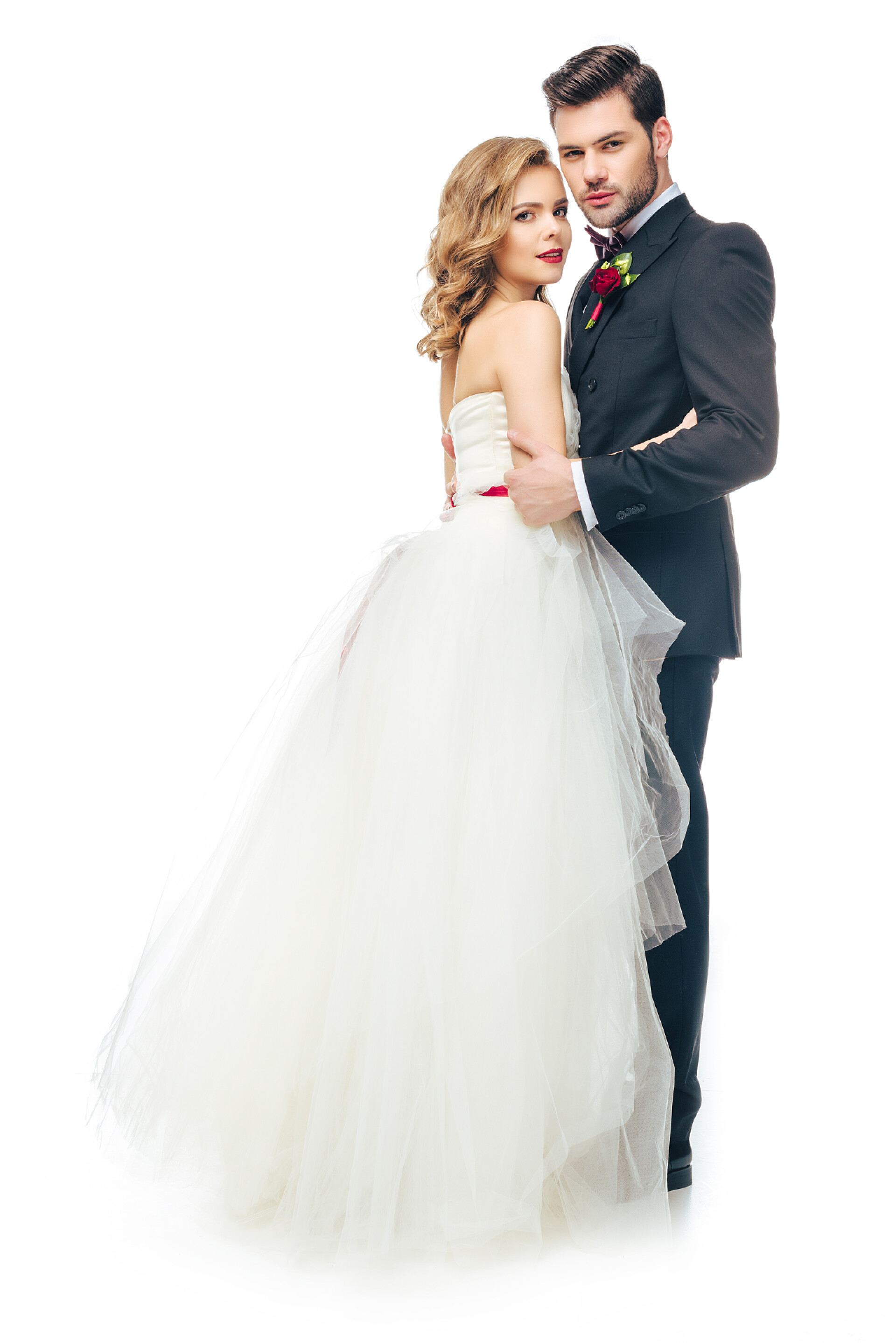 白色背景前拍照的拍婚夫妻侧面的婚礼情侣拥抱对方, 并期待在白色的摄像头隔离