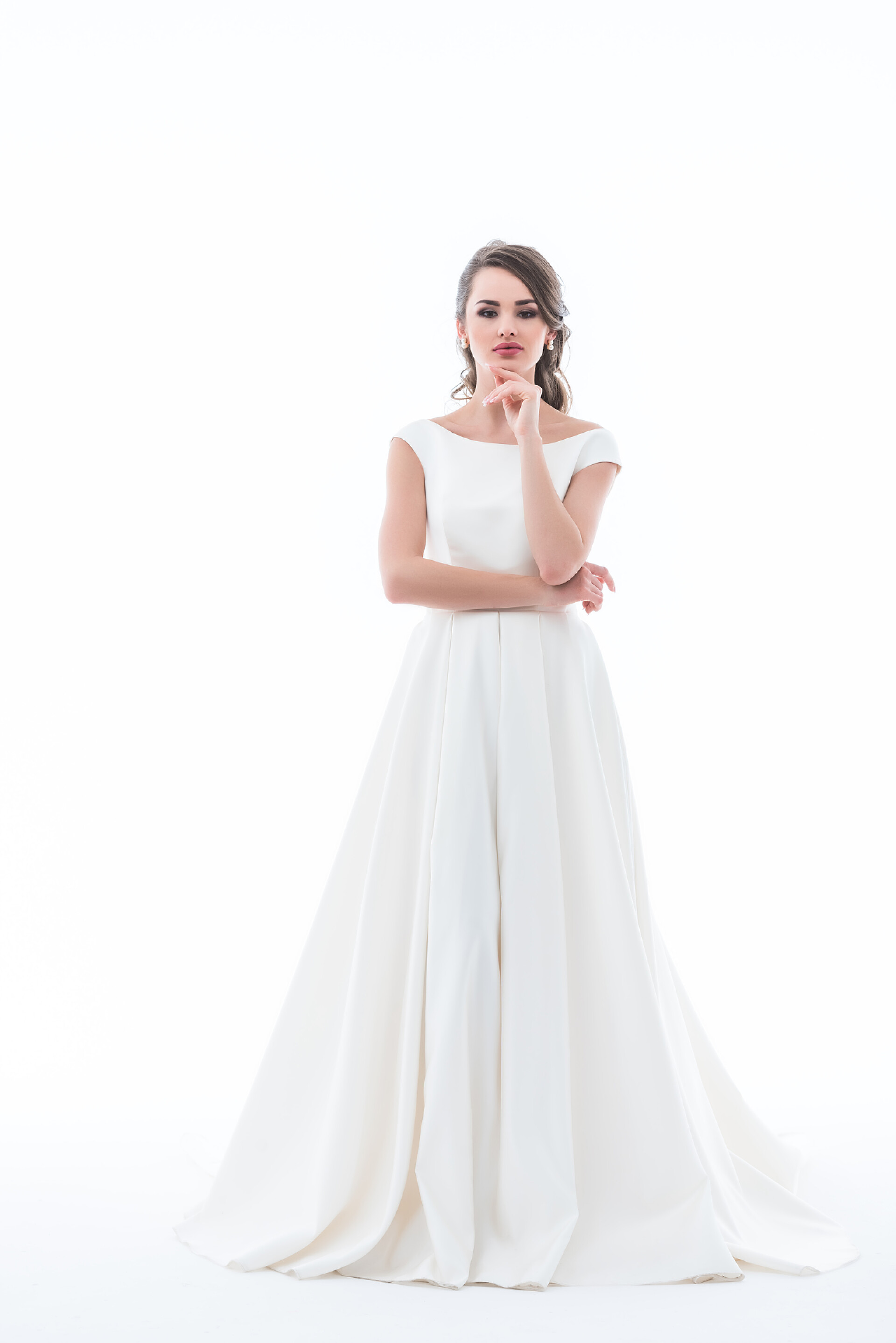 白色背景墙拍照的新娘体贴的新娘摆在传统的婚纱礼服, 孤立的白色