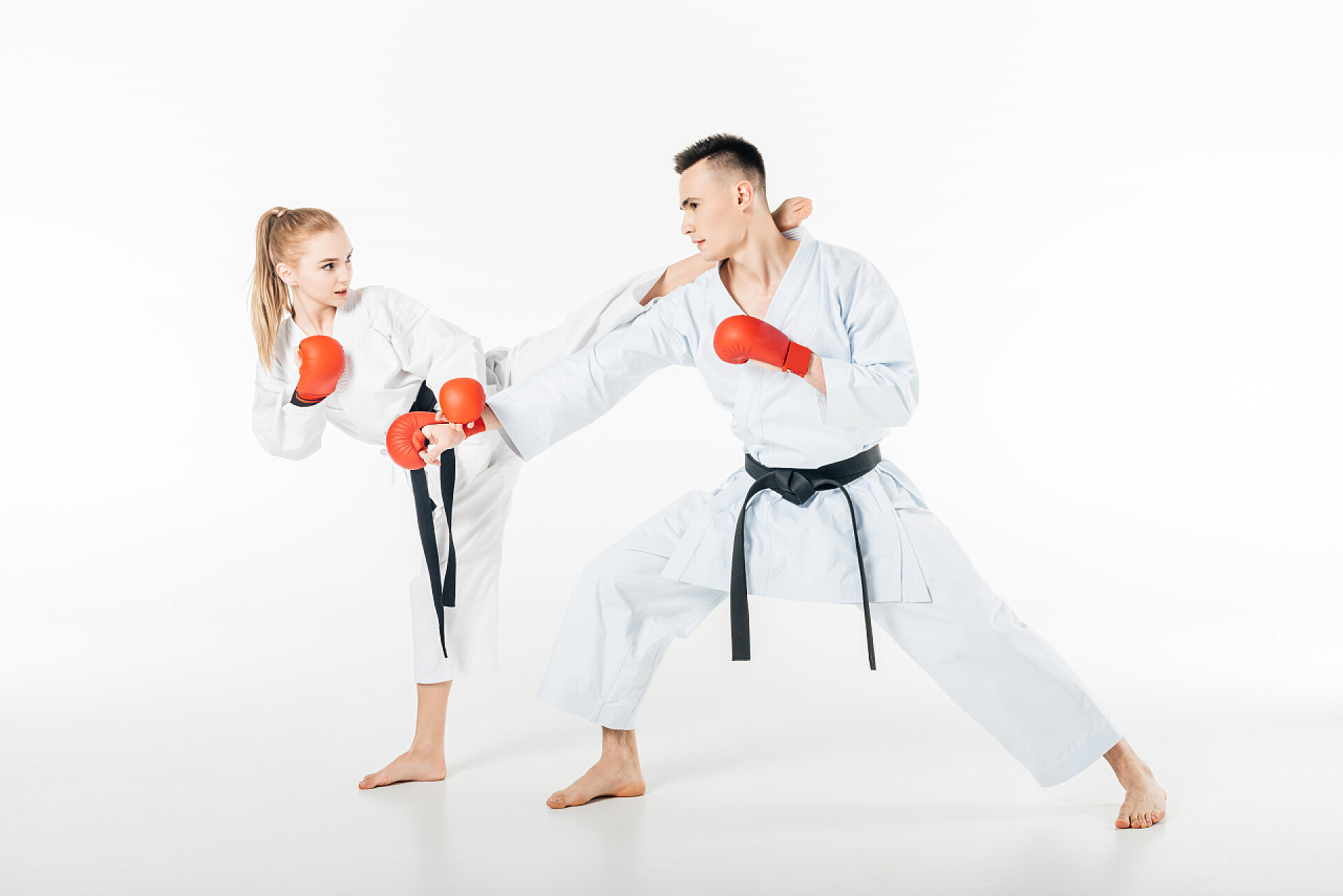 白色背景墙一个女人和男人在比试年轻的空手道战士训练与红色手套被隔绝在白色