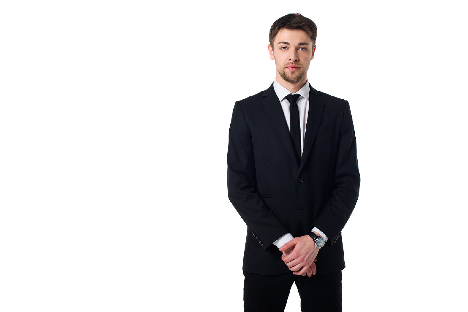 在白色背景前穿着西服的男人英俊的特工在黑色西装的肖像看着在白色的相机隔离