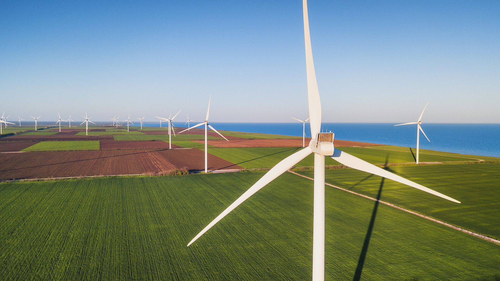 蓝天白云下的风车发电机风电站在绿色领域。替代能源发展的概念与理念