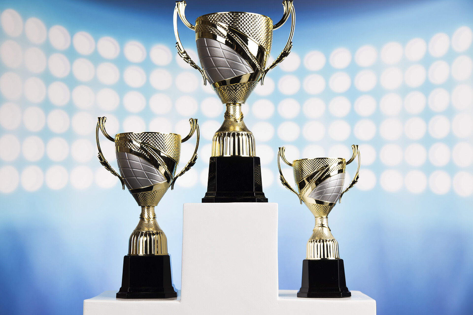 蓝色背景下的三个不同的奖杯优胜者讲台体育标志
