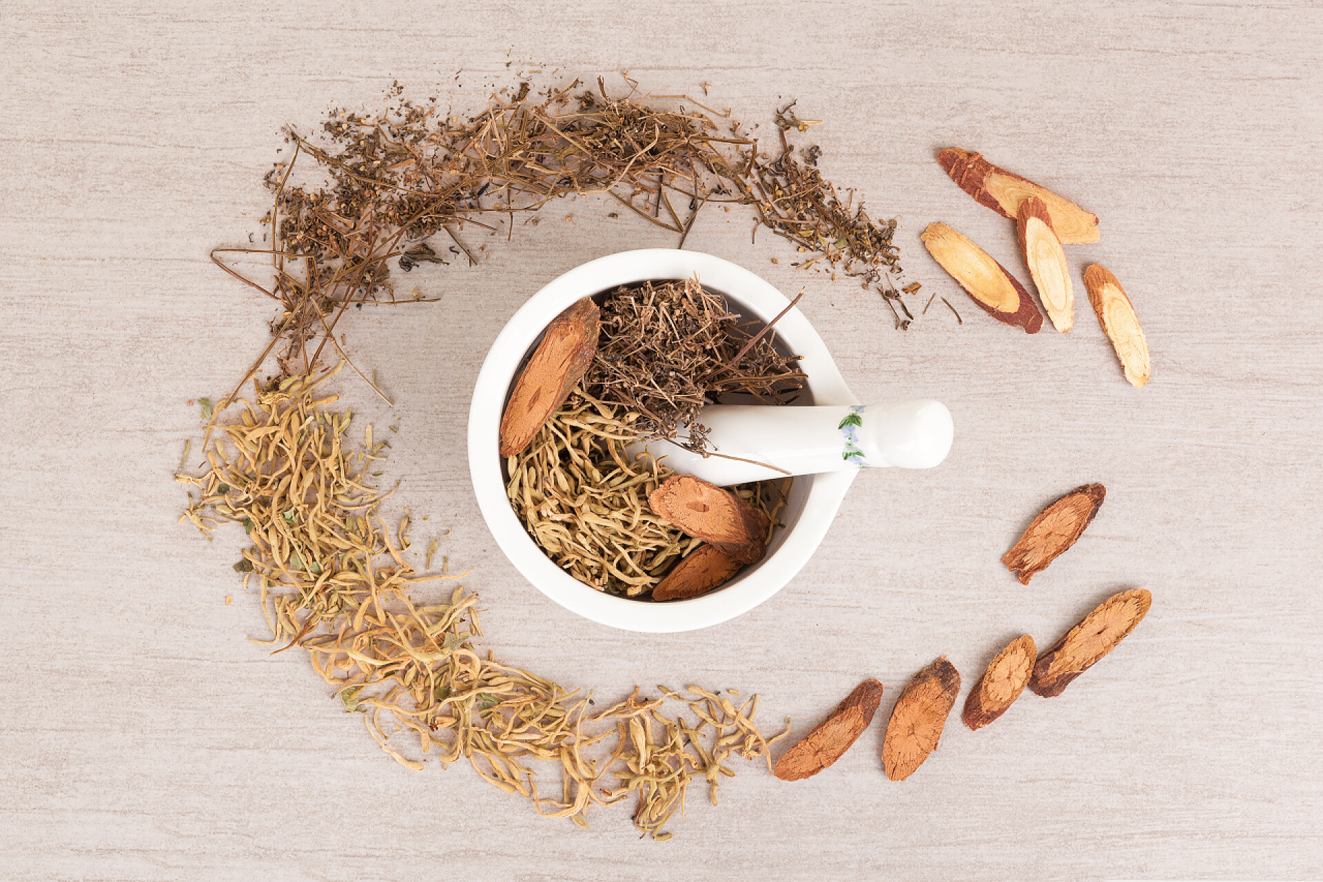 地上的中药材灰色背景下的中药与砂浆.