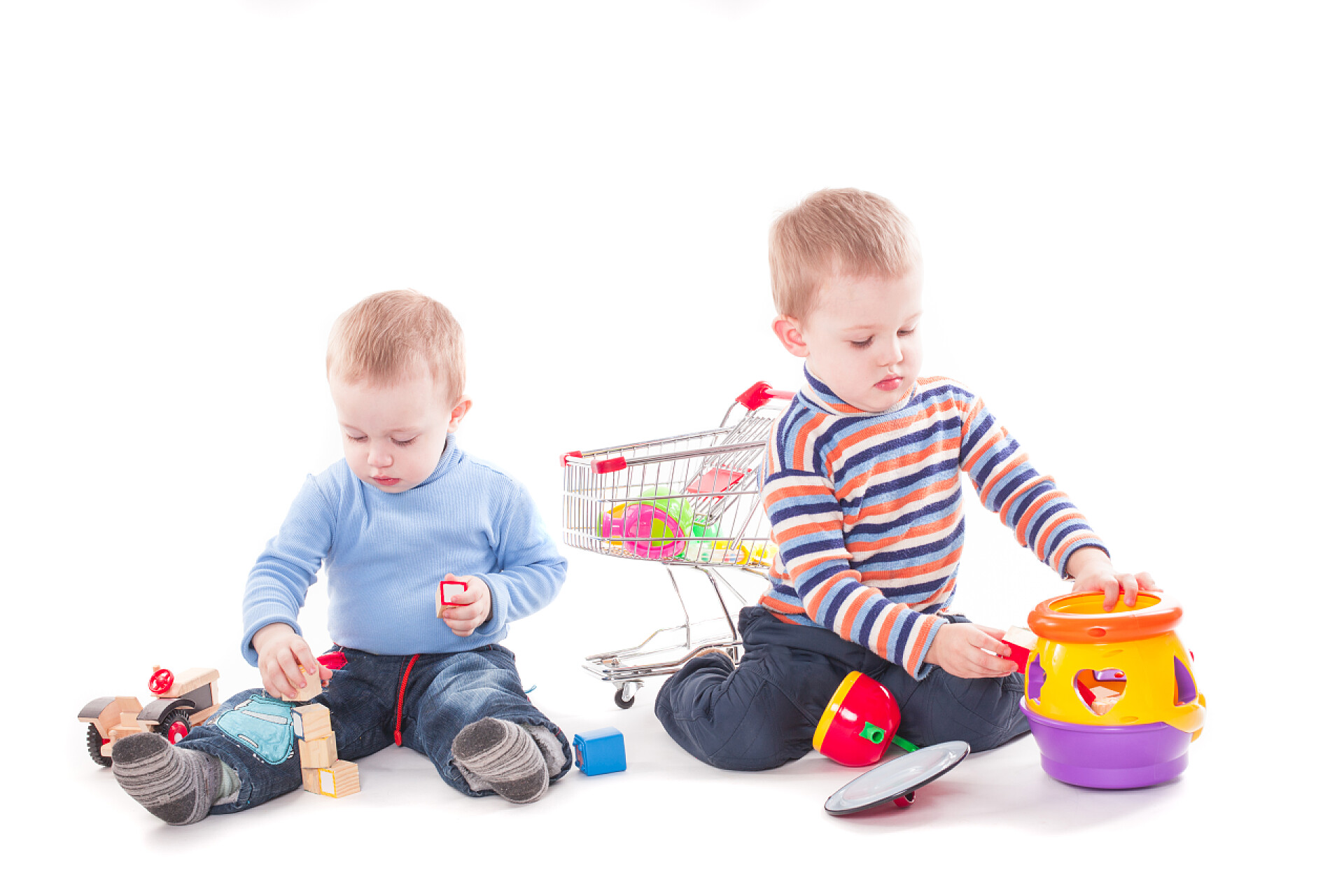 在白色背景墙前的两个小孩有趣的孩子玩教育玩具