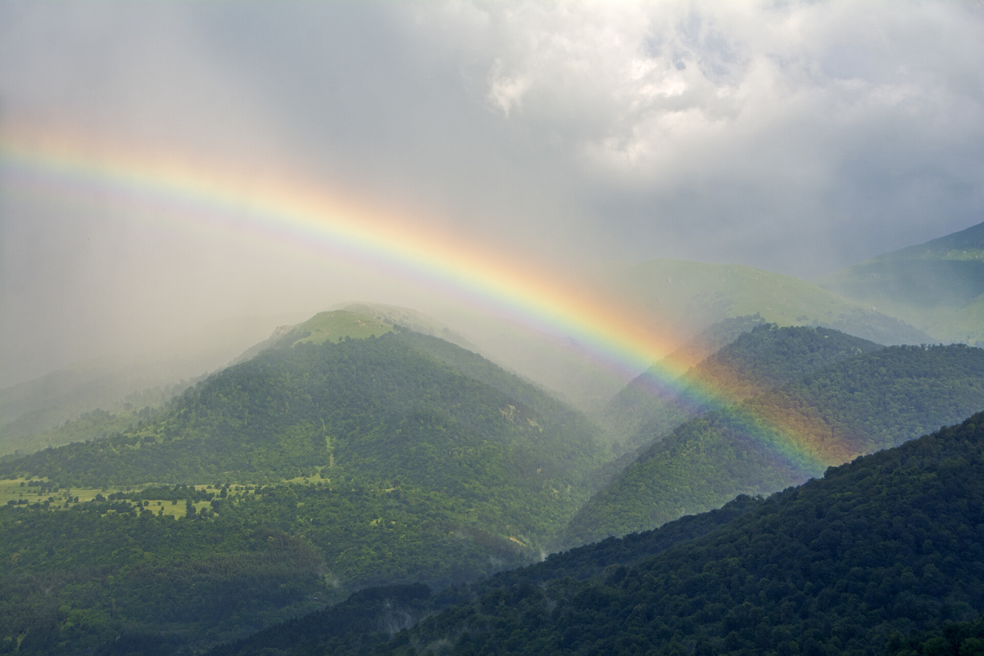 天空白云下的山谷和彩虹在 Dilijan 的山脉、森林和薄雾背景下, 一大片美丽的彩虹