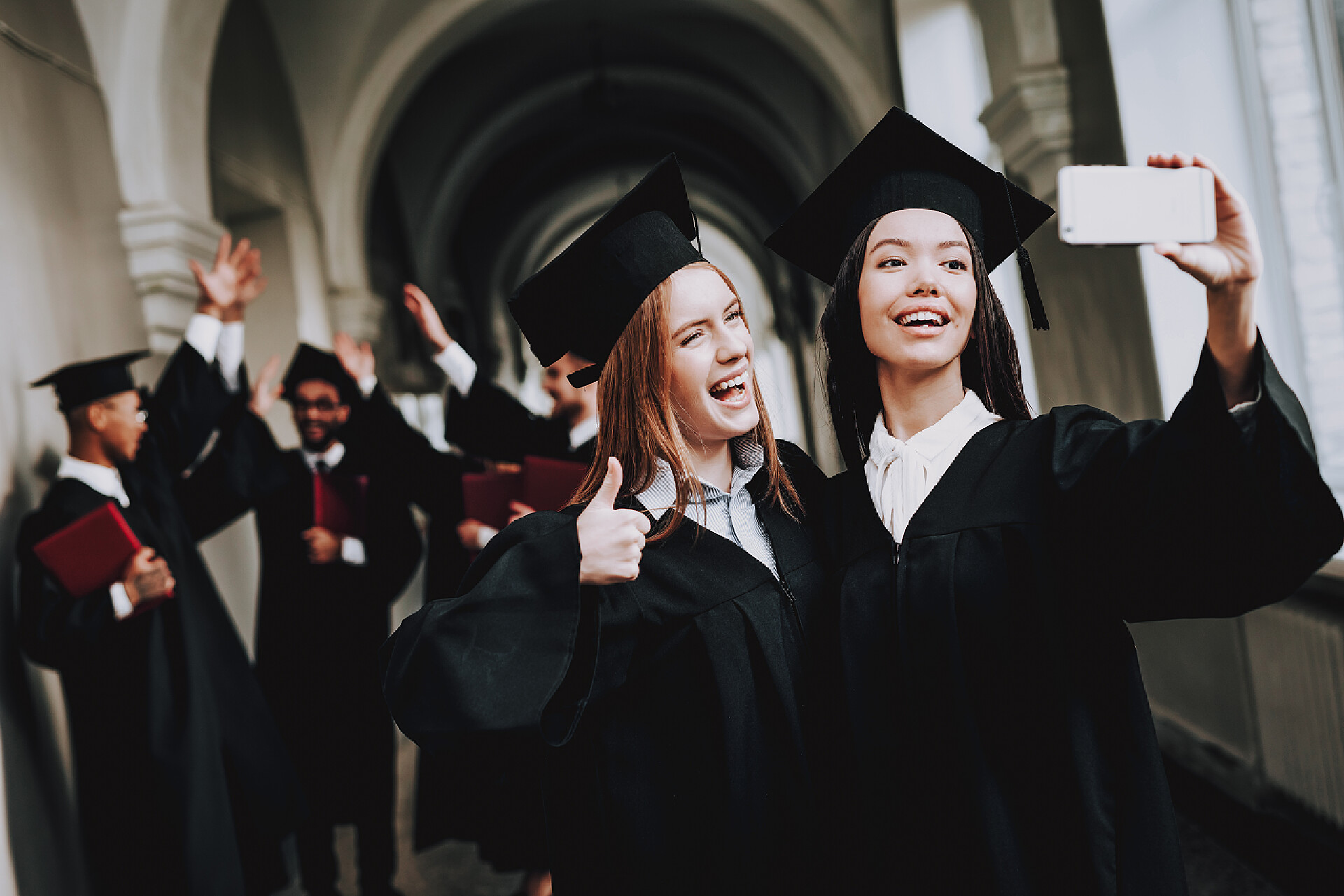 在国外毕业的一群年轻人塞尔菲建筑。幸福。女孩。情报。文凭。大学。毕业。快乐。心情很好大学。开朗。庆祝。帽。校园。黑。知识。砂浆板.