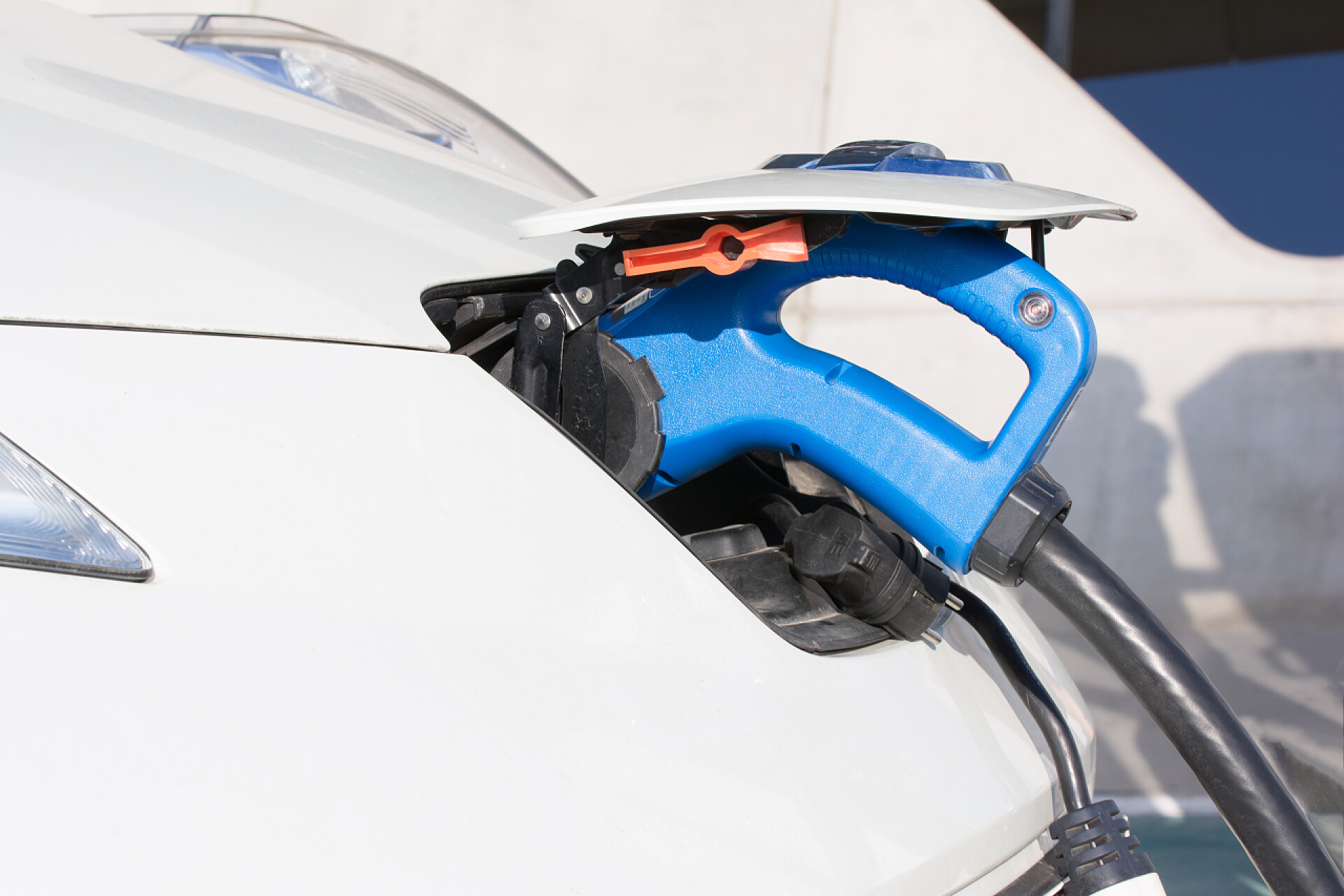 一个蓝色的加油管在给汽车加油Electric car charging on charge station. Electromobility environment friendly. Copy space. Refueling electro mobile.