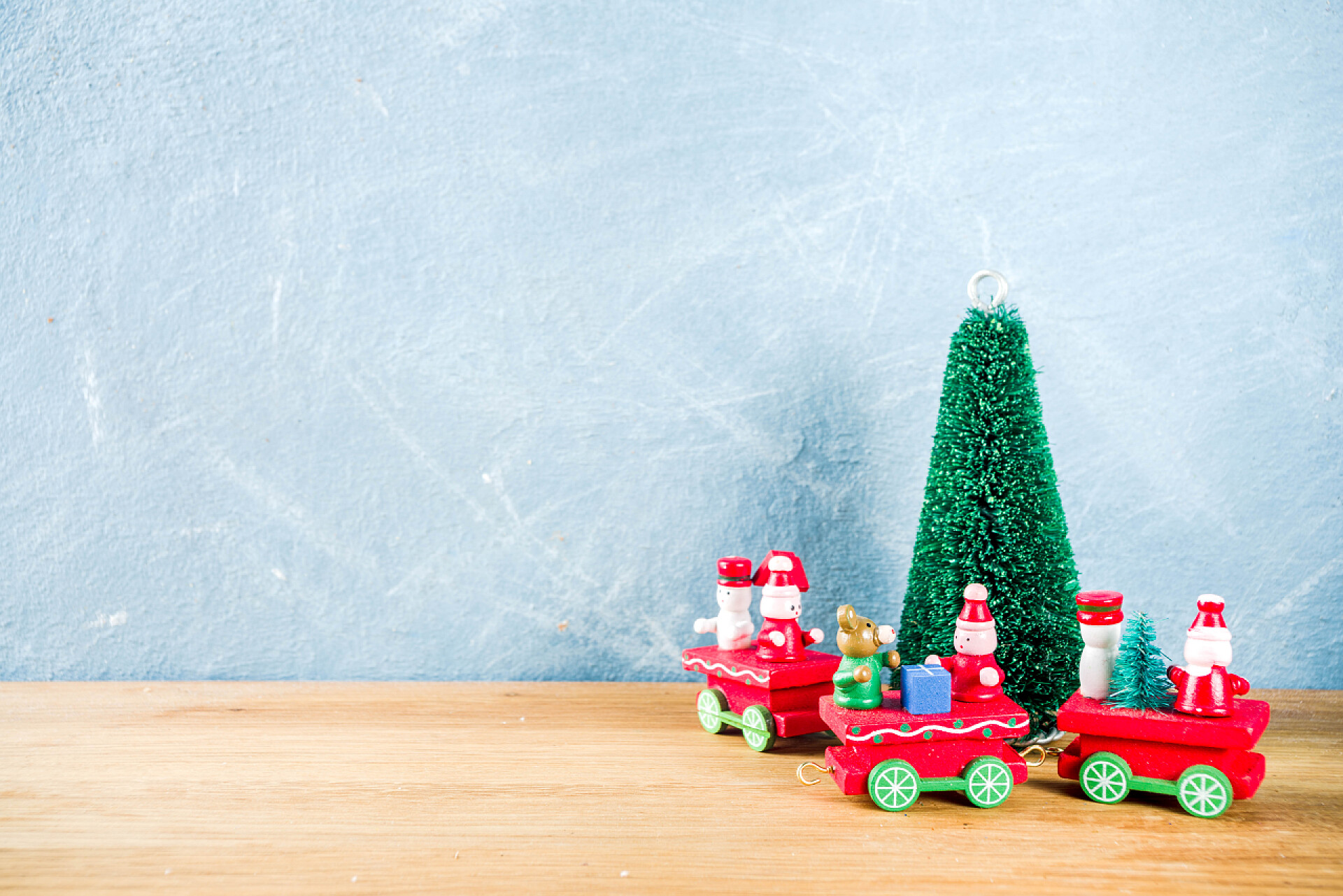 蓝色的背景墙木质的桌子上的那小车和绿色的树圣诞节概念背景与人造圣诞树, 新年装饰和礼品盒, 复制空间