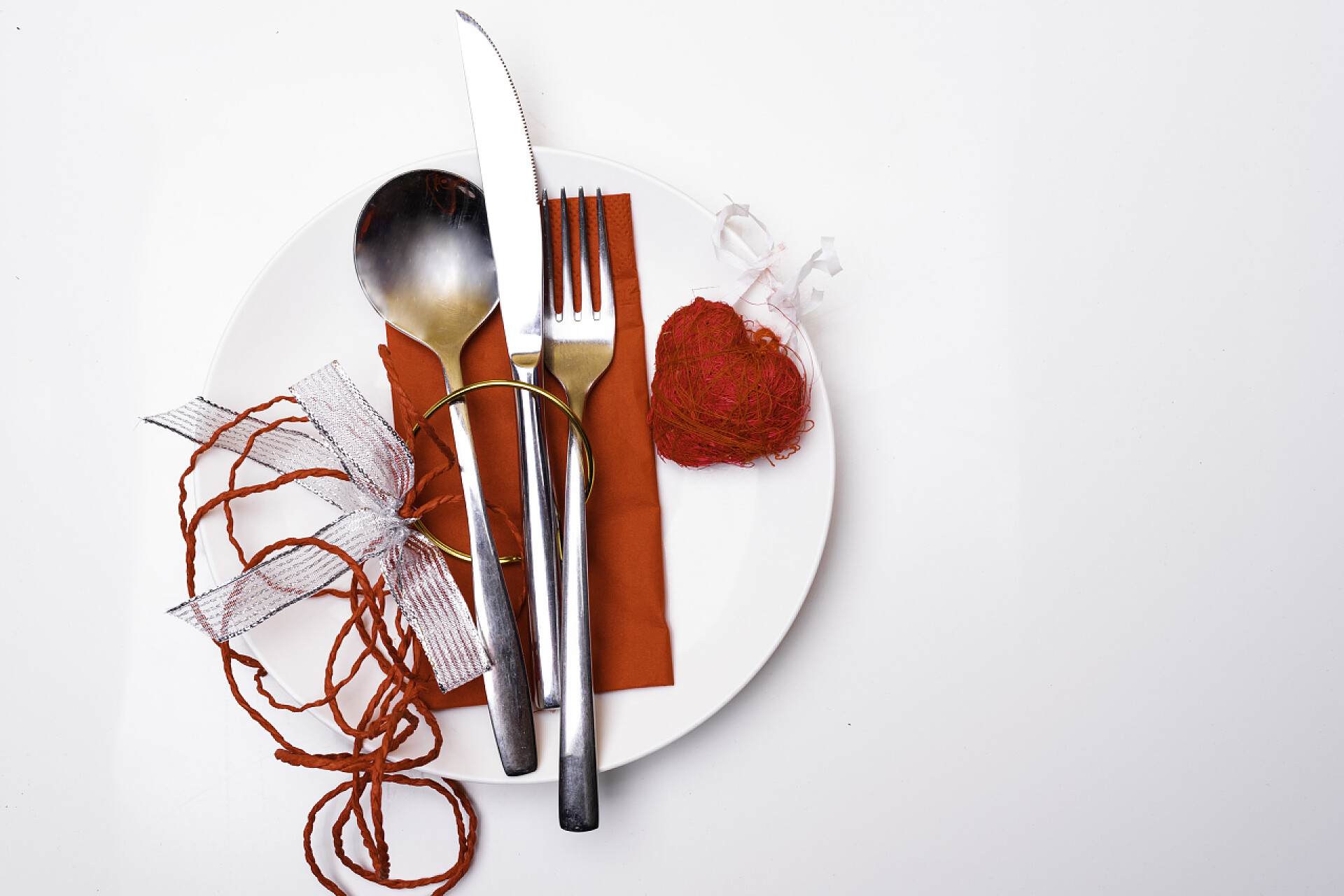 白色桌子上的白色盘子里的餐具圣诞节, 新年, 情人节银器庆祝作为邀请设计背景与装饰弓和金戒指