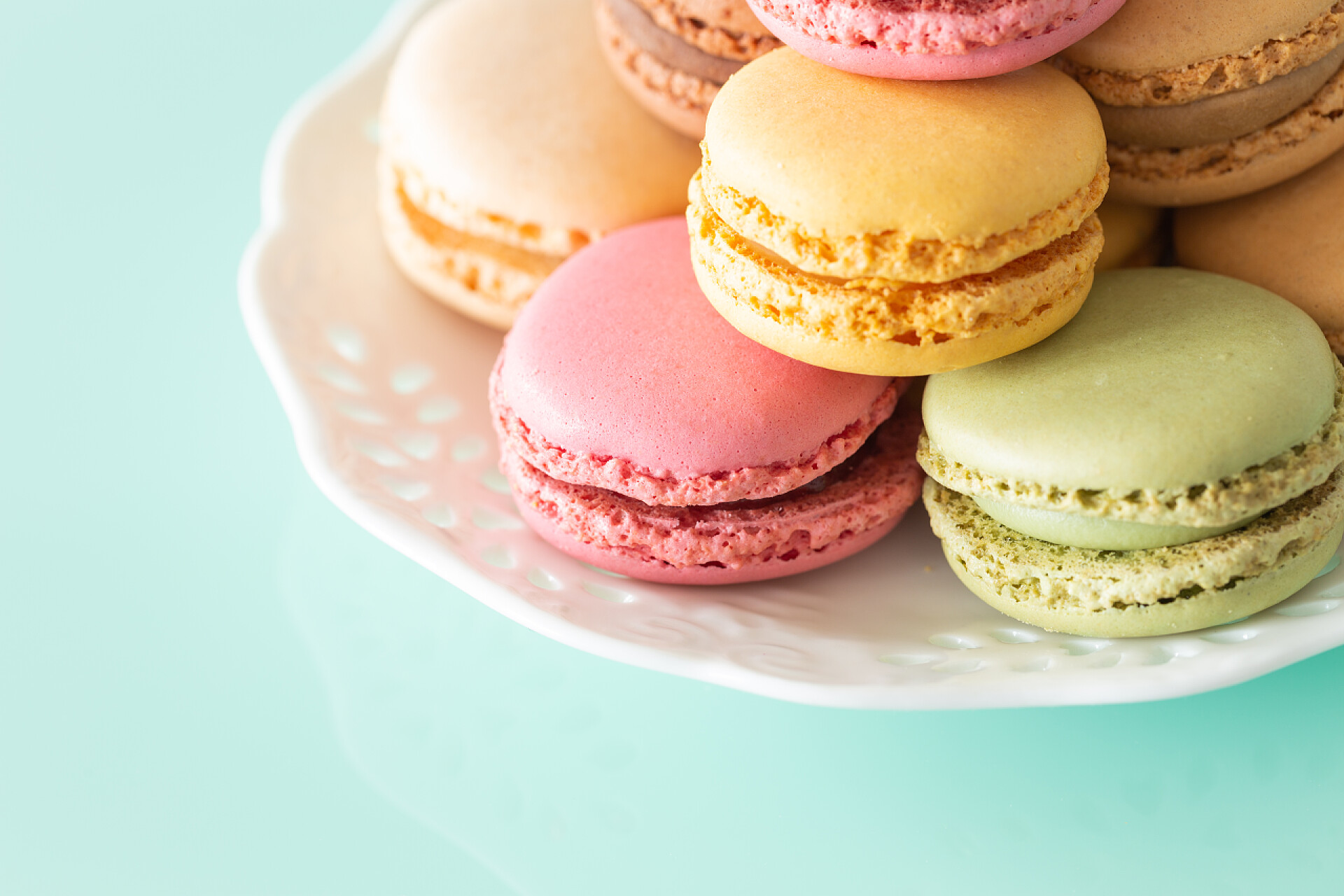 蓝色的桌子上有好多种颜色的马卡龙在柔和的颜色的马卡龙蛋糕上柔和的绿色玻璃背景