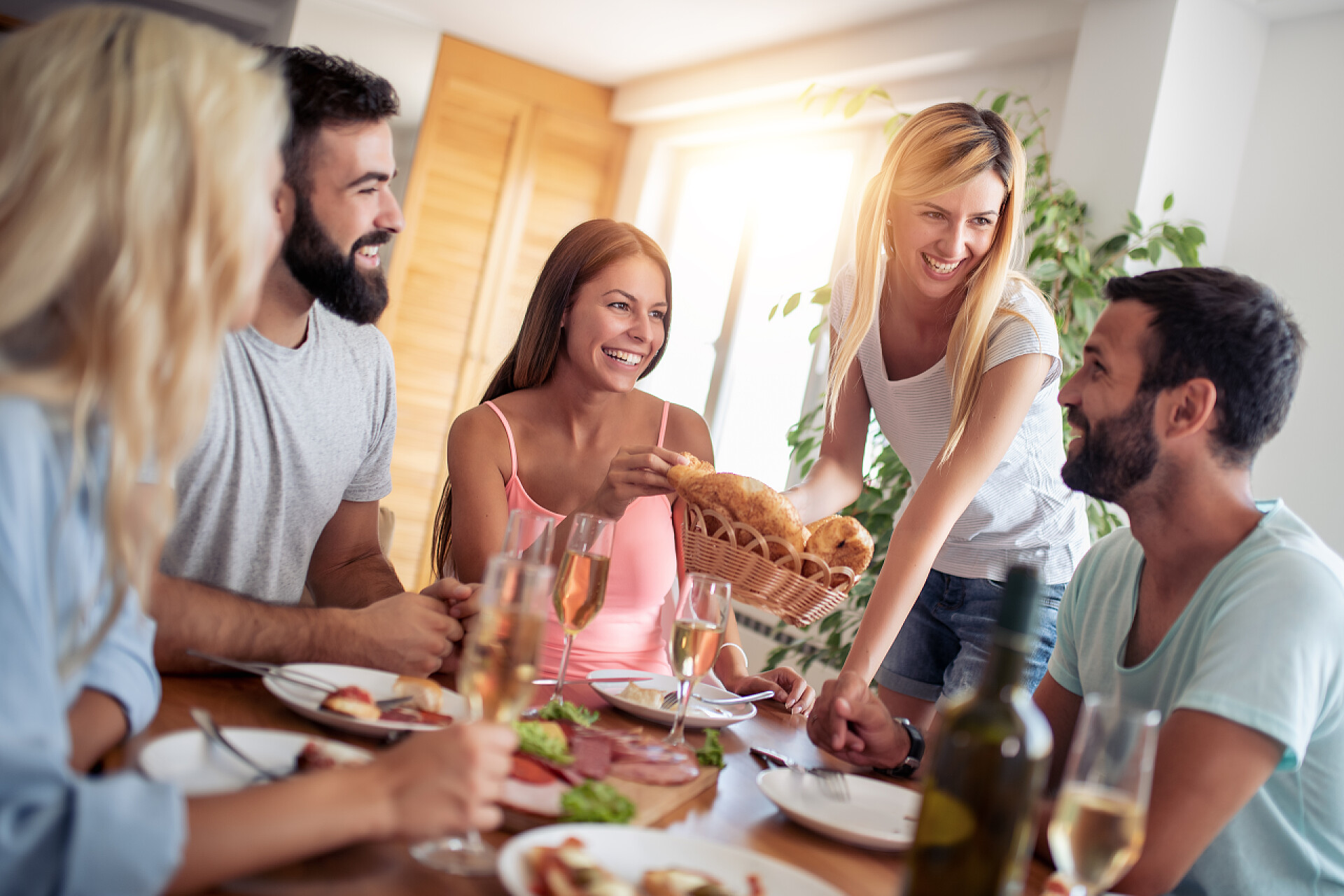 五个好朋友在家里聚餐微笑的朋友在家里一起吃午饭。人, 食物和饮料, 乐趣和假日概念