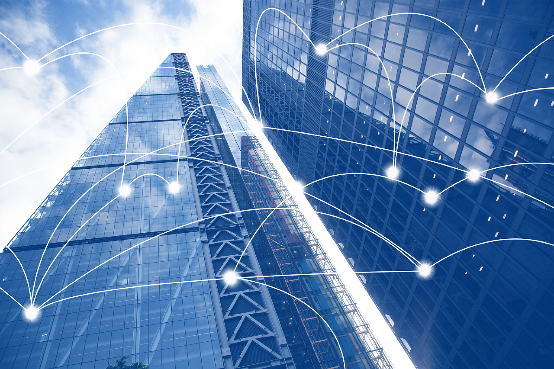 蓝天白云下的两座蓝色的高楼大厦聪明的城市和连接线。全球商业的互联网概念，摩天大楼