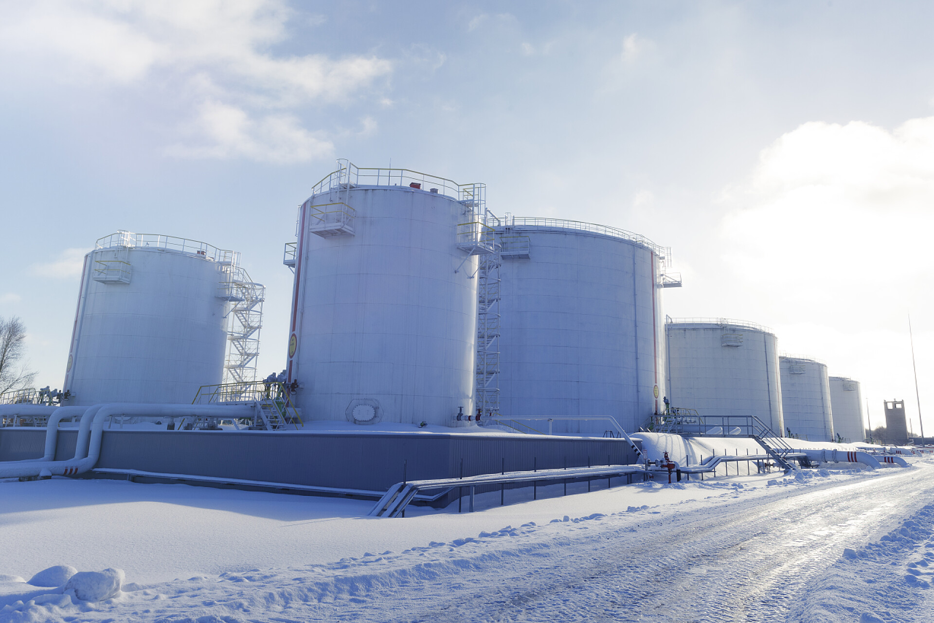 蓝天白云下石油产出的罐子排列的放在地面上石油产品储罐