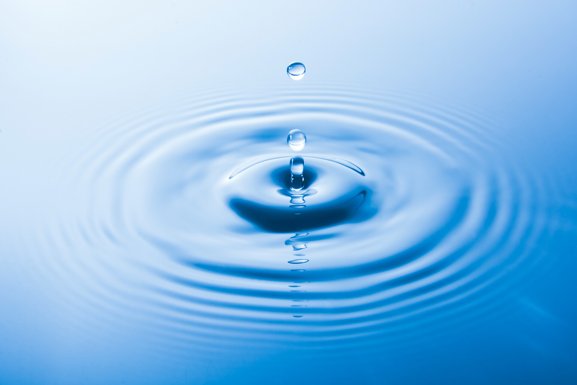 水滴在水面上水滴掉进水里会发出波浪。水溅或水滴背景. 