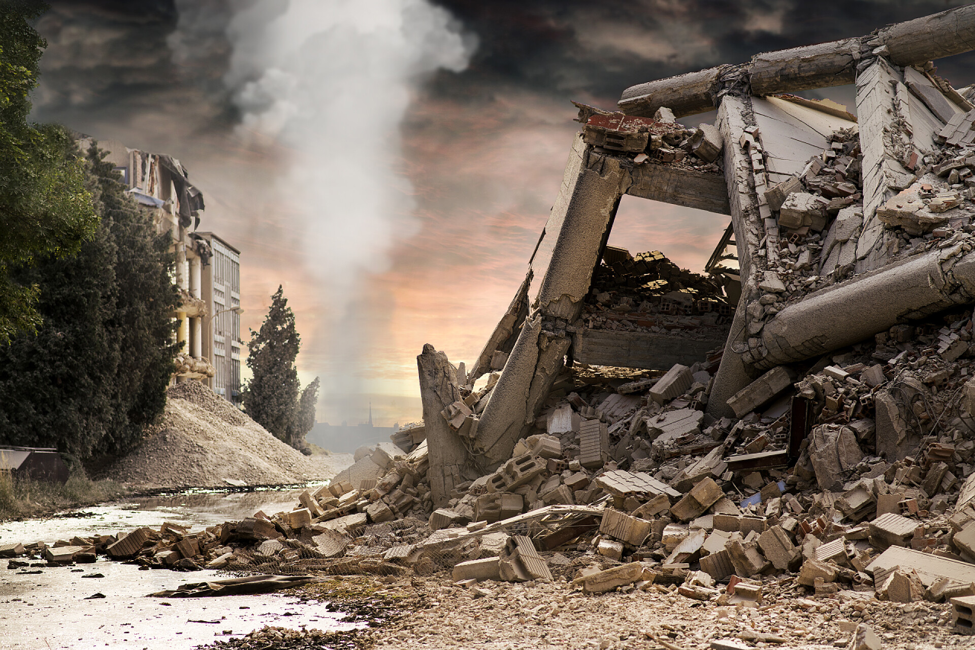 因工业需求而被扒迁的房屋在倒塌的混凝土工业大厦的看法以白色烟专栏在背景和深红色戏剧性的天空上述