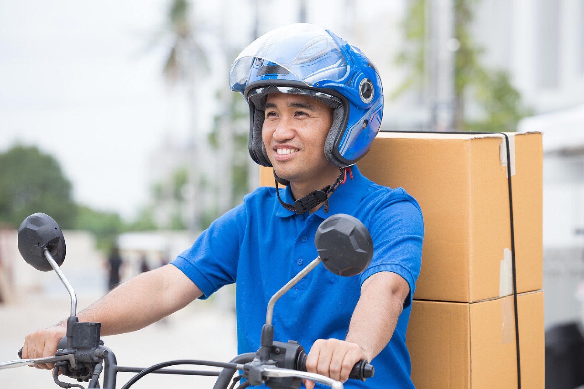一个快递员在辛勤的开着摩托送着货物Delivery boy on motorcycle with trunk parcel box driving to fast in rush. Courier delivering order online. Express delivery within specified time by scooter concept