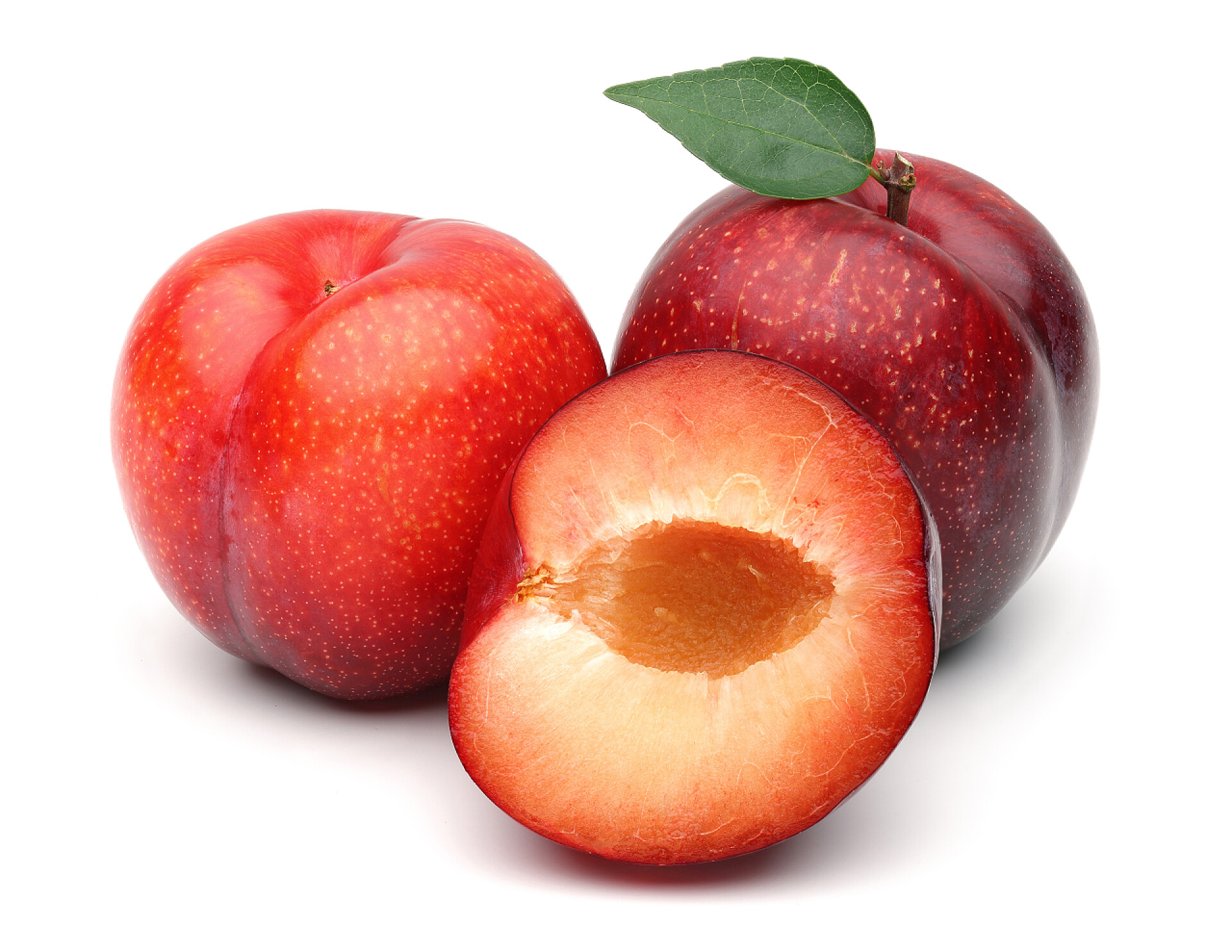 在白色的背景墙上有着两个完整的李子和一半的李子红色李子与叶子查出在白色背景