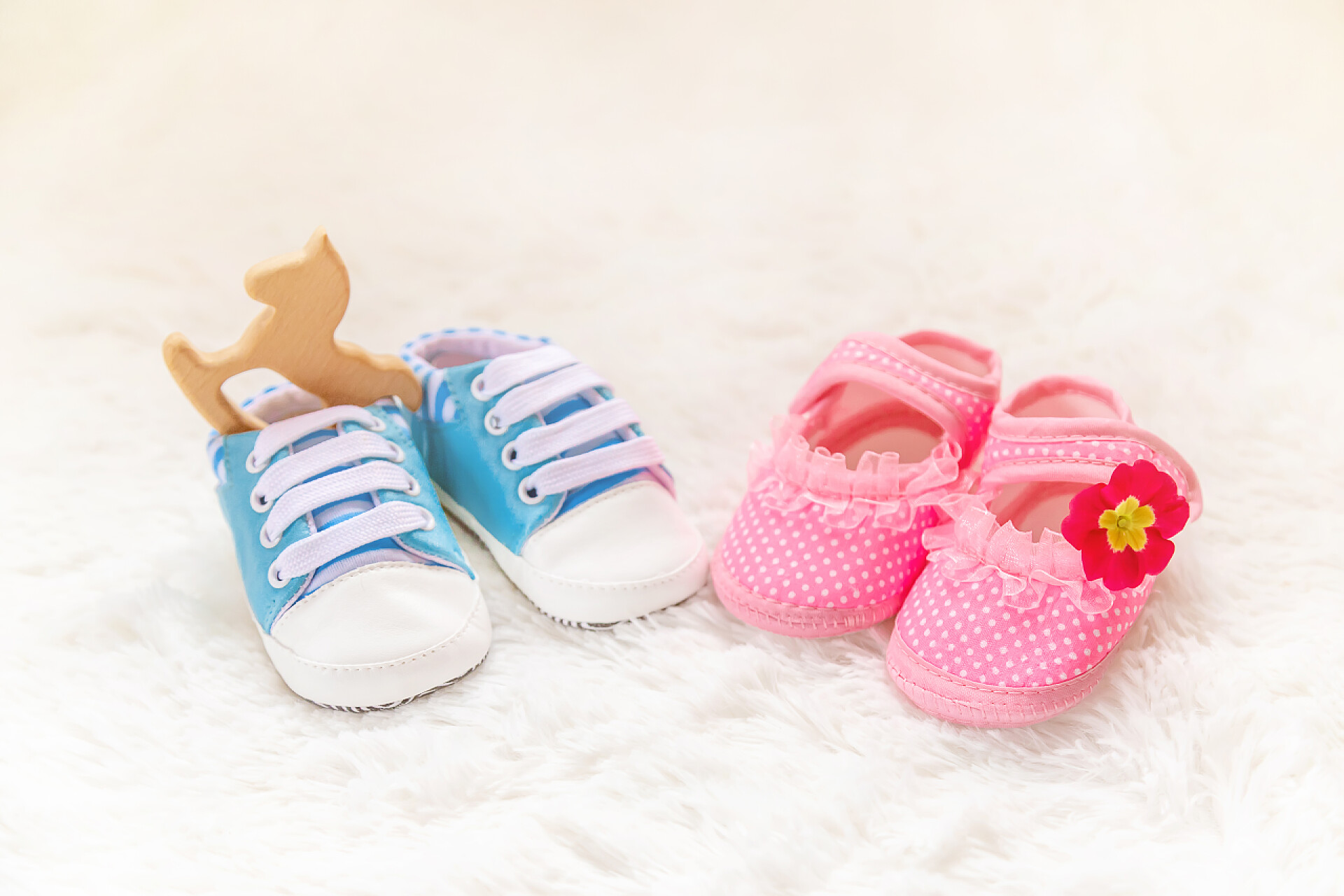 在白色的地毯上有量双小孩子的鞋男孩或女孩配件新生婴儿。选择性对焦.