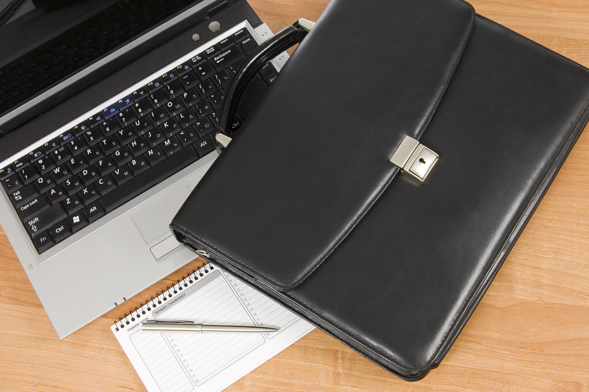 桌子上的公文包和笔记本仰视图黑色组合和计算机