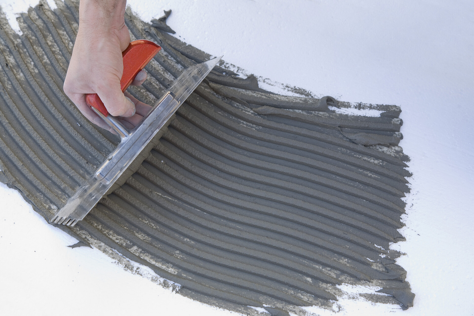 装修工人正在抹平水泥主放胶粘剂