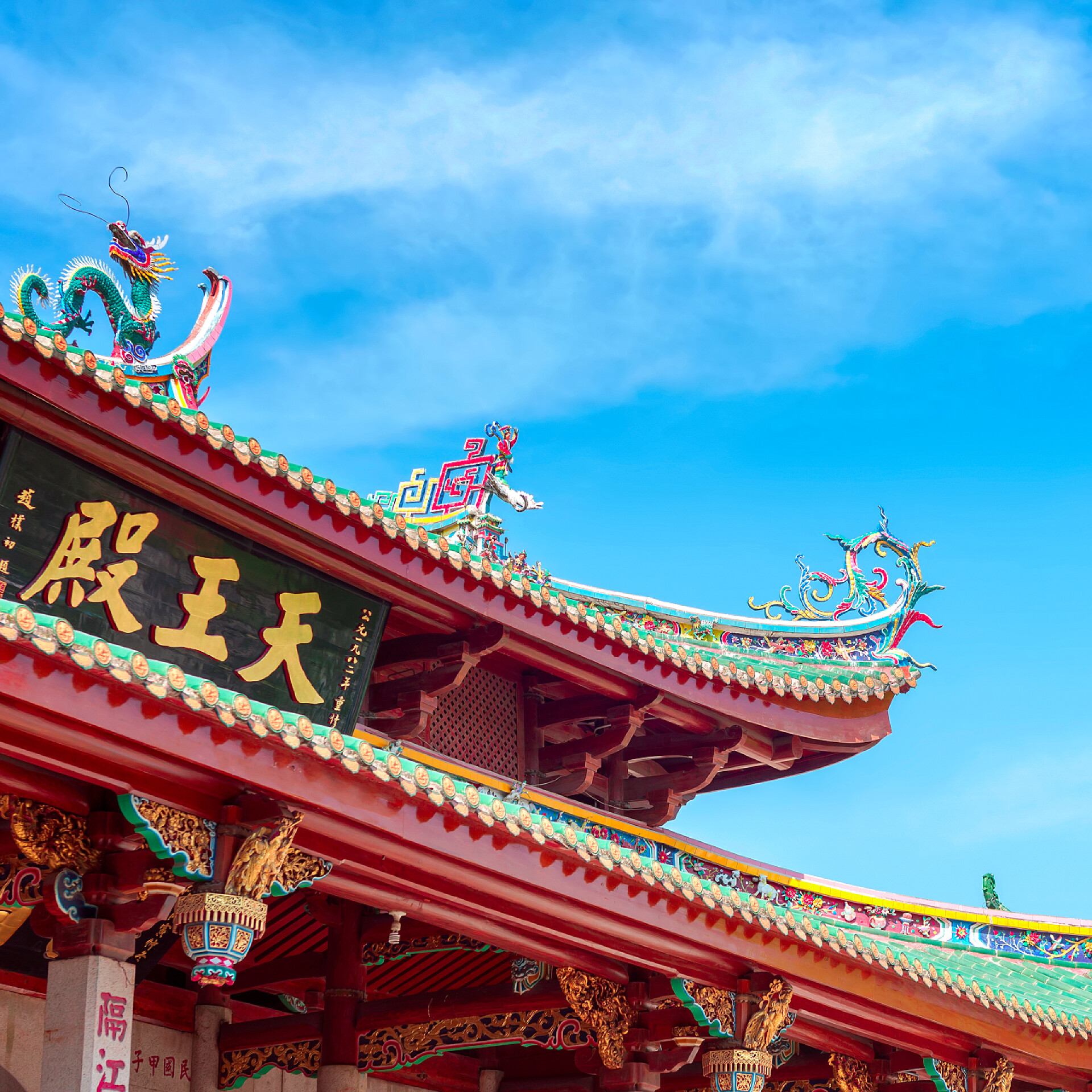 蓝天白云下古建筑的一角中国龙雕像