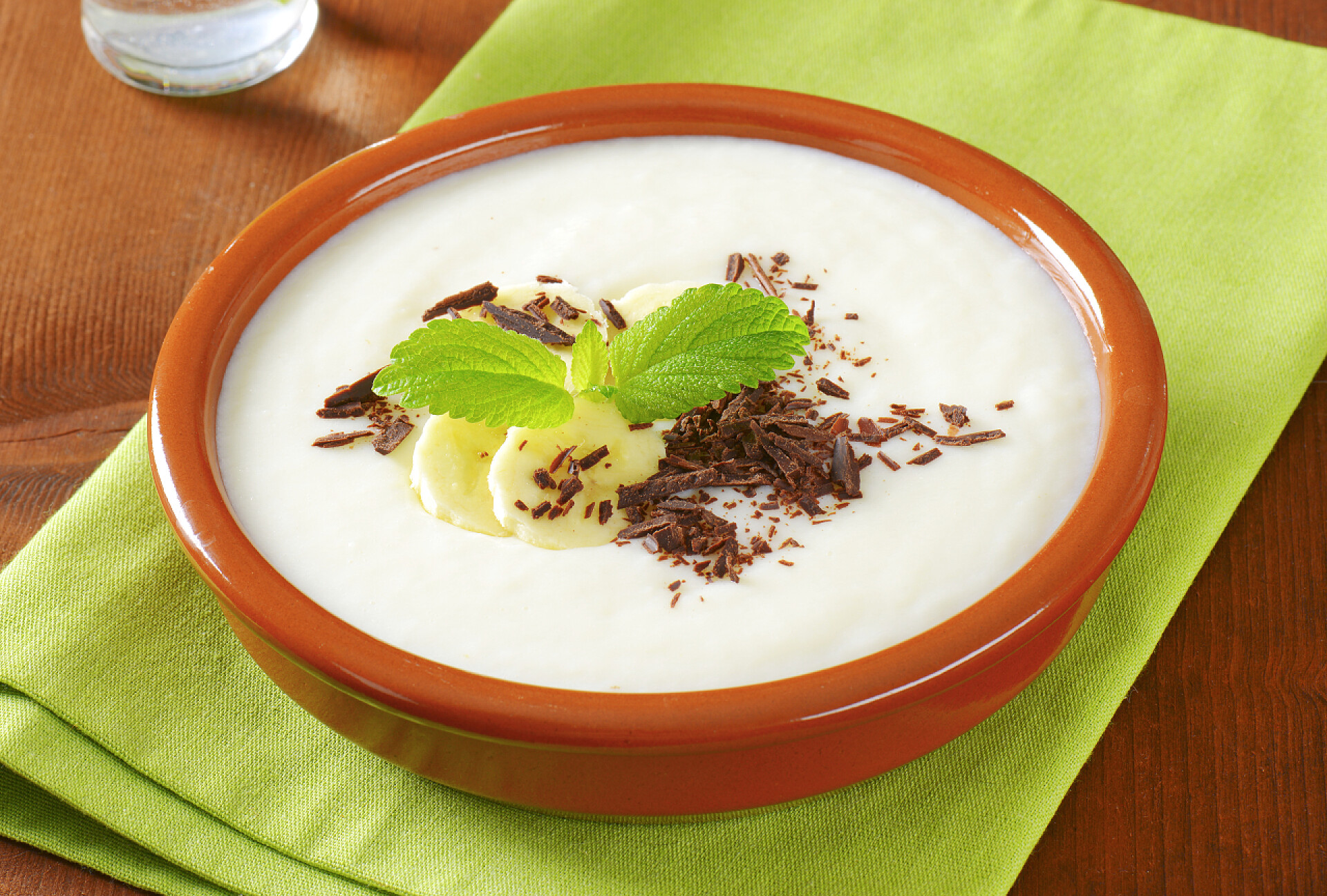 桌子上的一碗牛奶布丁与香蕉和巧克力的泥的米饭布丁。