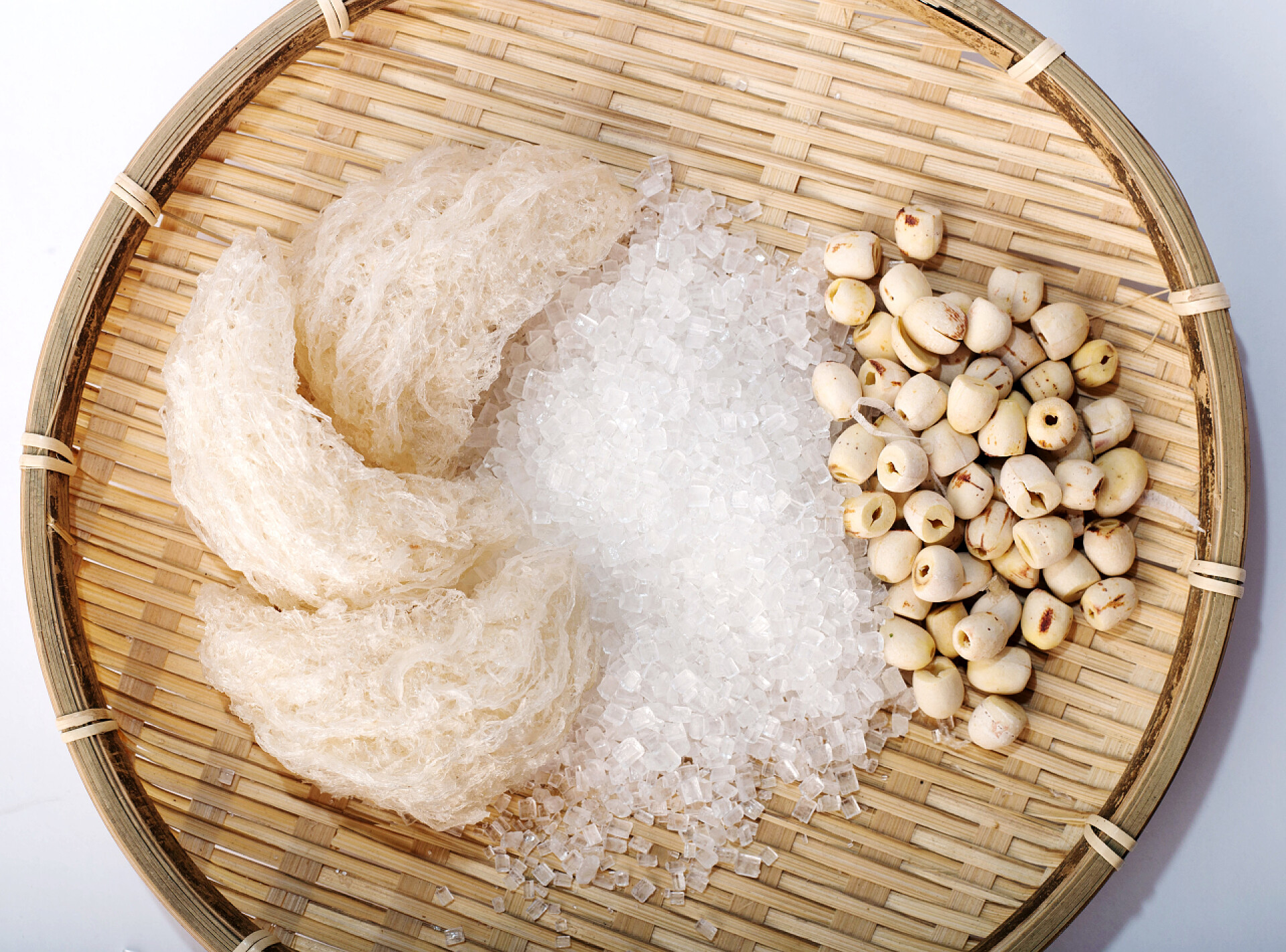 俯拍篮子里面的燕窝和莲子鸟的巢或 salanganes 与白色背景上的莲花豆