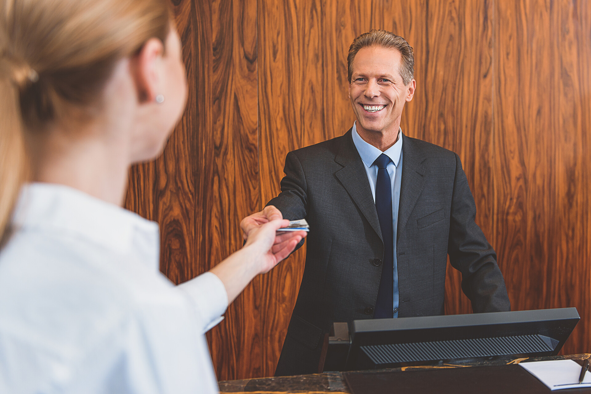 酒店人员做登记酒店经理的微笑欢迎妇女