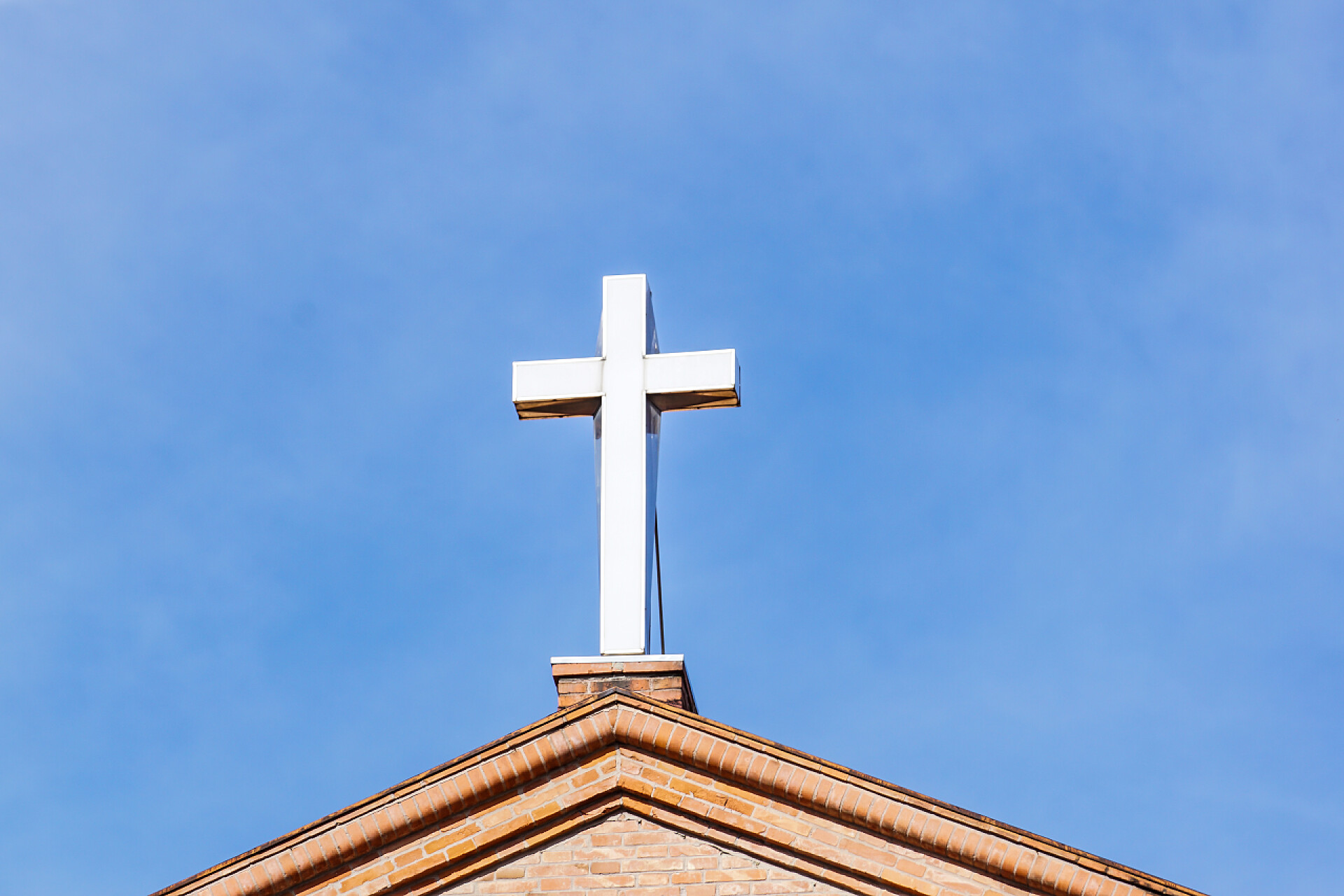 在蓝天下的钟楼上的十字架十字架上现代基督教会在蓝蓝的天空下