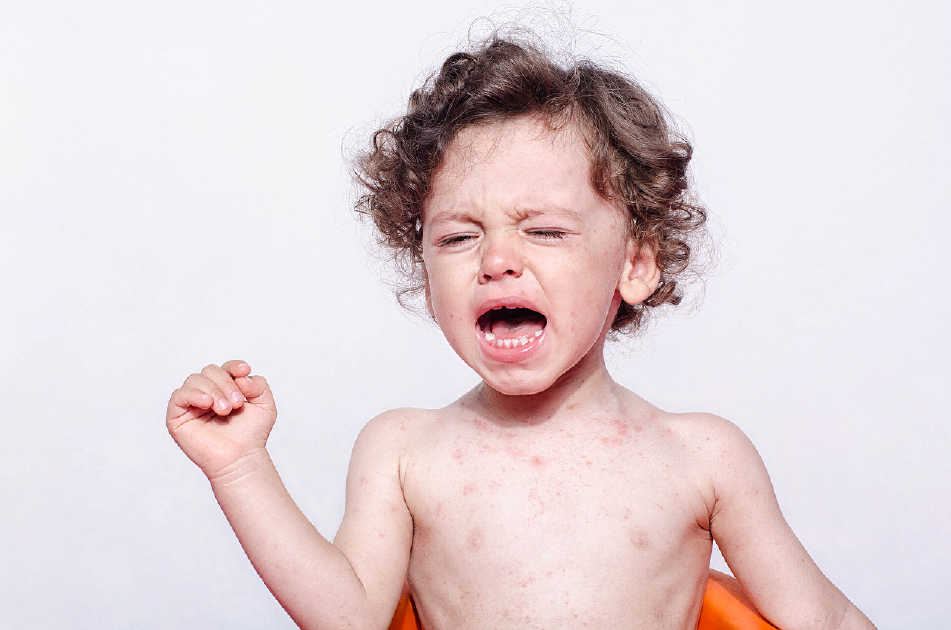 白色背景上一个正在哭泣的儿童一个可爱生病的婴儿男孩哭的肖像. 