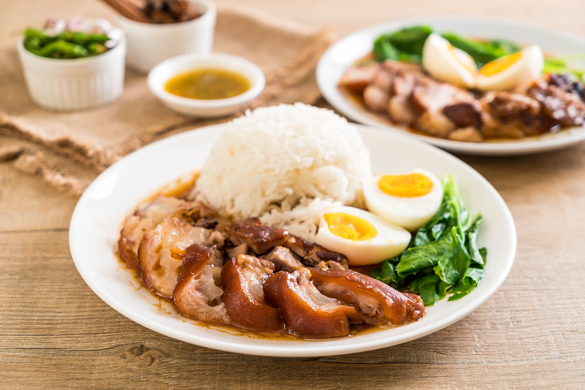 桌子上摆着猪腿肉米饭和蔬菜炖的猪腿肉饭