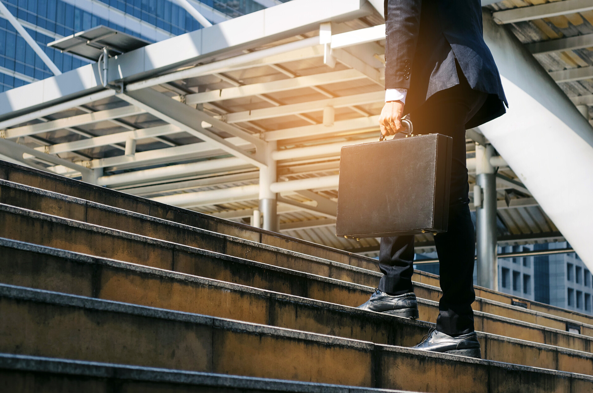 男人手提公文包走楼梯年轻英俊的商人拿着公文包和步行上楼去上班的时间在早晨在城市, 决心, 信心, 生活方式, 高峰时刻, 成长和成功的概念