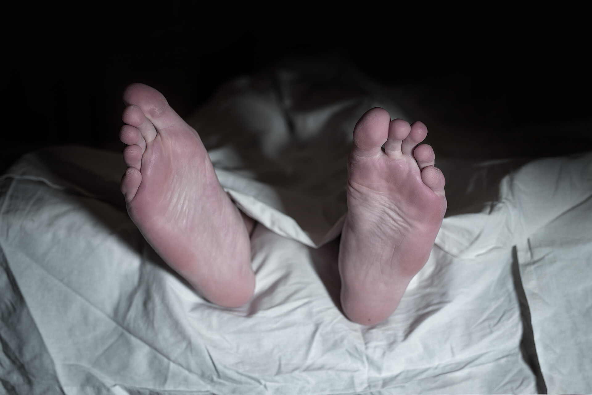 死者躺在地板上的白布下