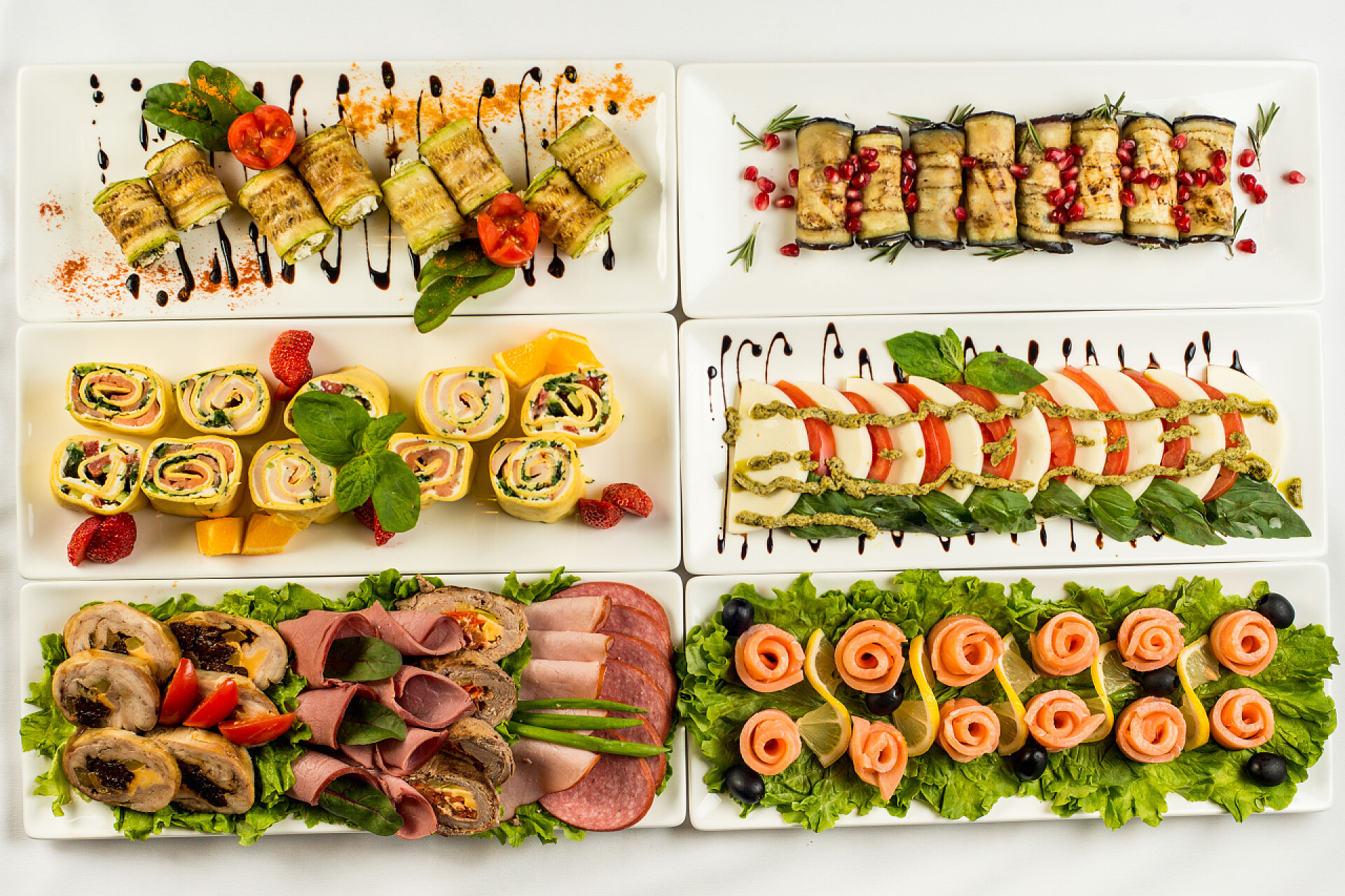 白色背景上陈列着假日不同的美食在白色的背景白色盘子在假日吃不同的零食。厨房, 菜单, 食品概念。美味佳肴