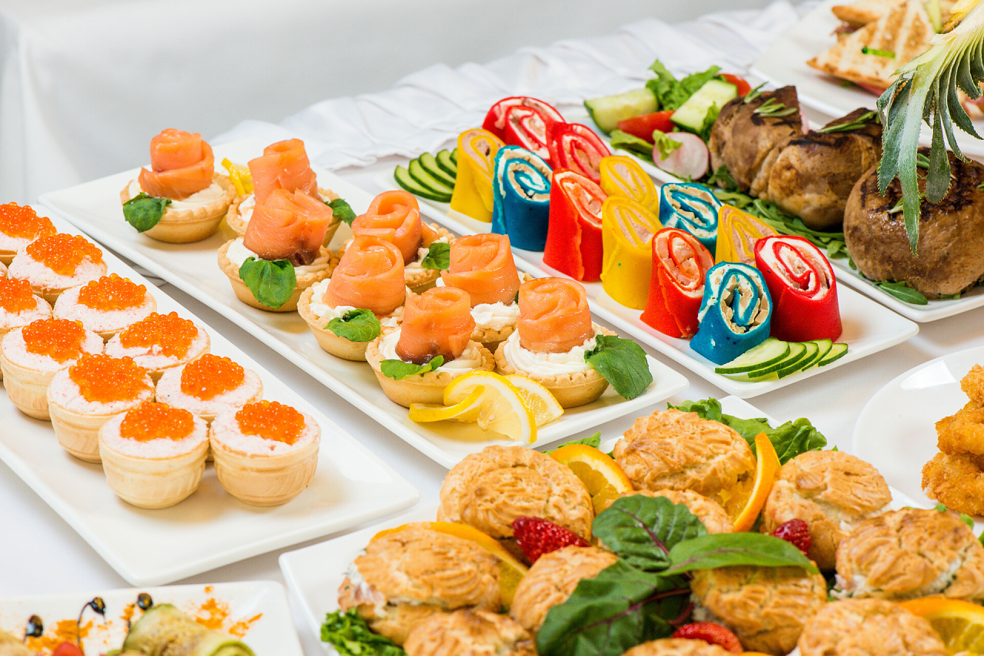 在色的背景上陈列着假日的不同美味佳肴在白色的背景白色盘子在假日吃不同的零食。厨房, 菜单, 食品概念。美味佳肴