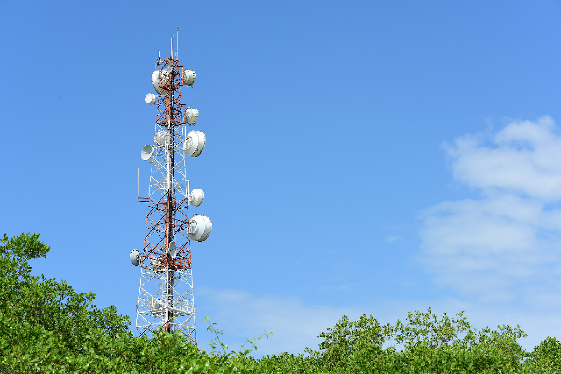 蓝天白云下的无线通信天线微波系统。无线通信天线, 具有明亮的天空。带蓝天天线的通信塔.