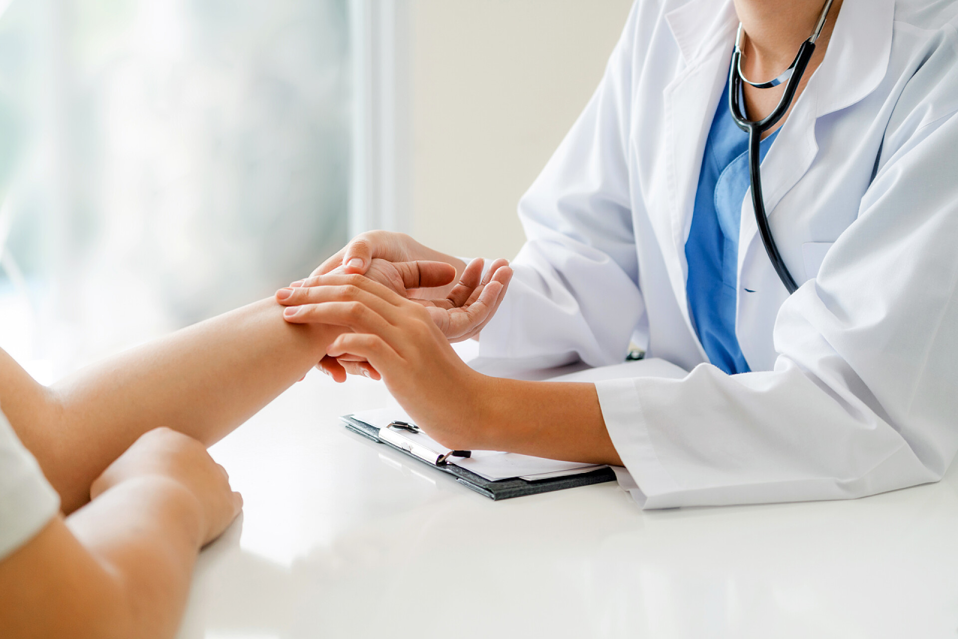 女医生在医院办公室为病人把脉女医生在医院办公室与女性病人交谈, 同时检查病人的手脉搏。医疗和医疗服务.